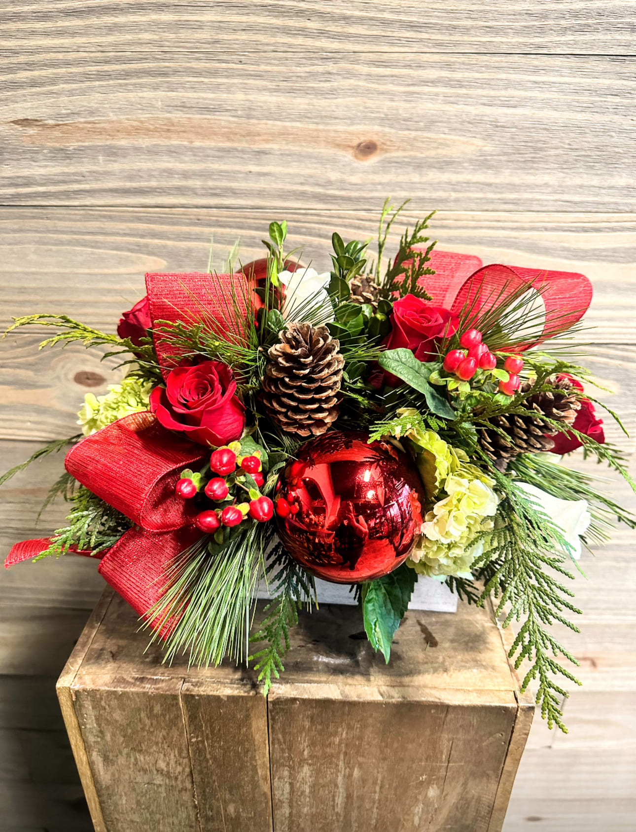 Santa's Sleigh - A beautiful centerpiece arrangement with fuller flowers including roses, hydrangeas, hypericum etc. in a festive holiday box style arrangement.  