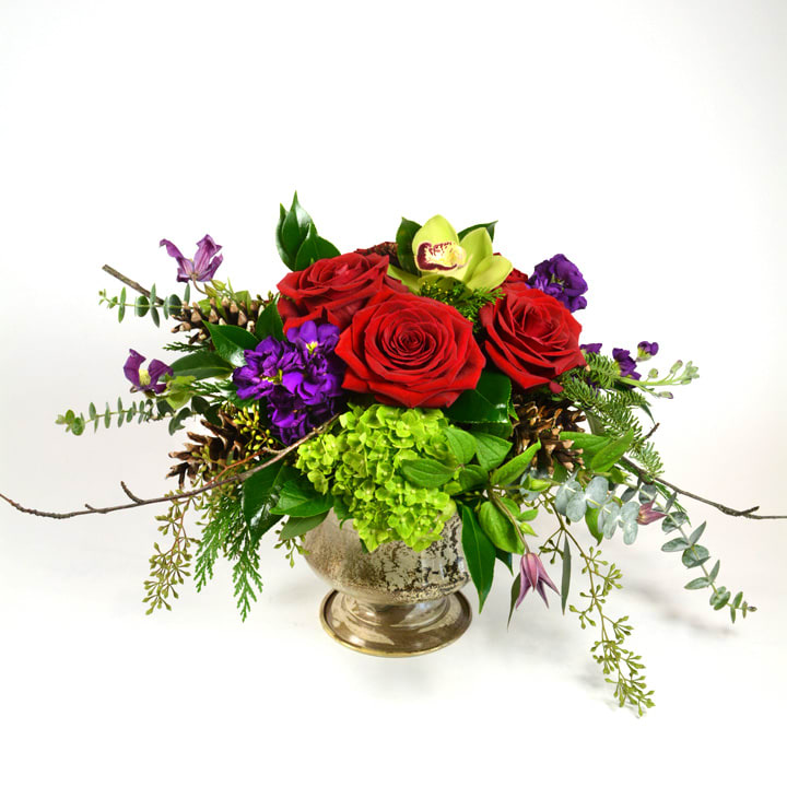 Modern Christmas - Vivid red roses, purple stock and apple green cymbidium orchids with winter pine and cones and birch in our pedestal compote perfect for the table.