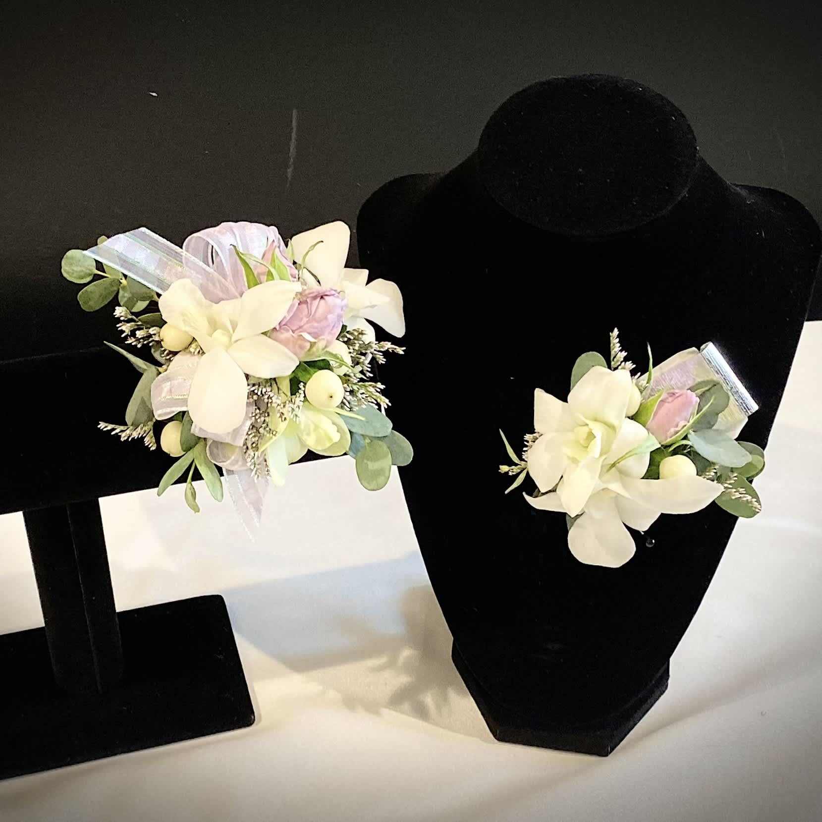 Dendrobium Orchid Corsage + Boutonniere Set - Refined dendrobium orchids are a stunning way to elevate your prom or homecoming game!  Please note white or fuchsia orchids and accent color(s) in the special instructions section.   If no color is noted, we will default to white flowers and accents.