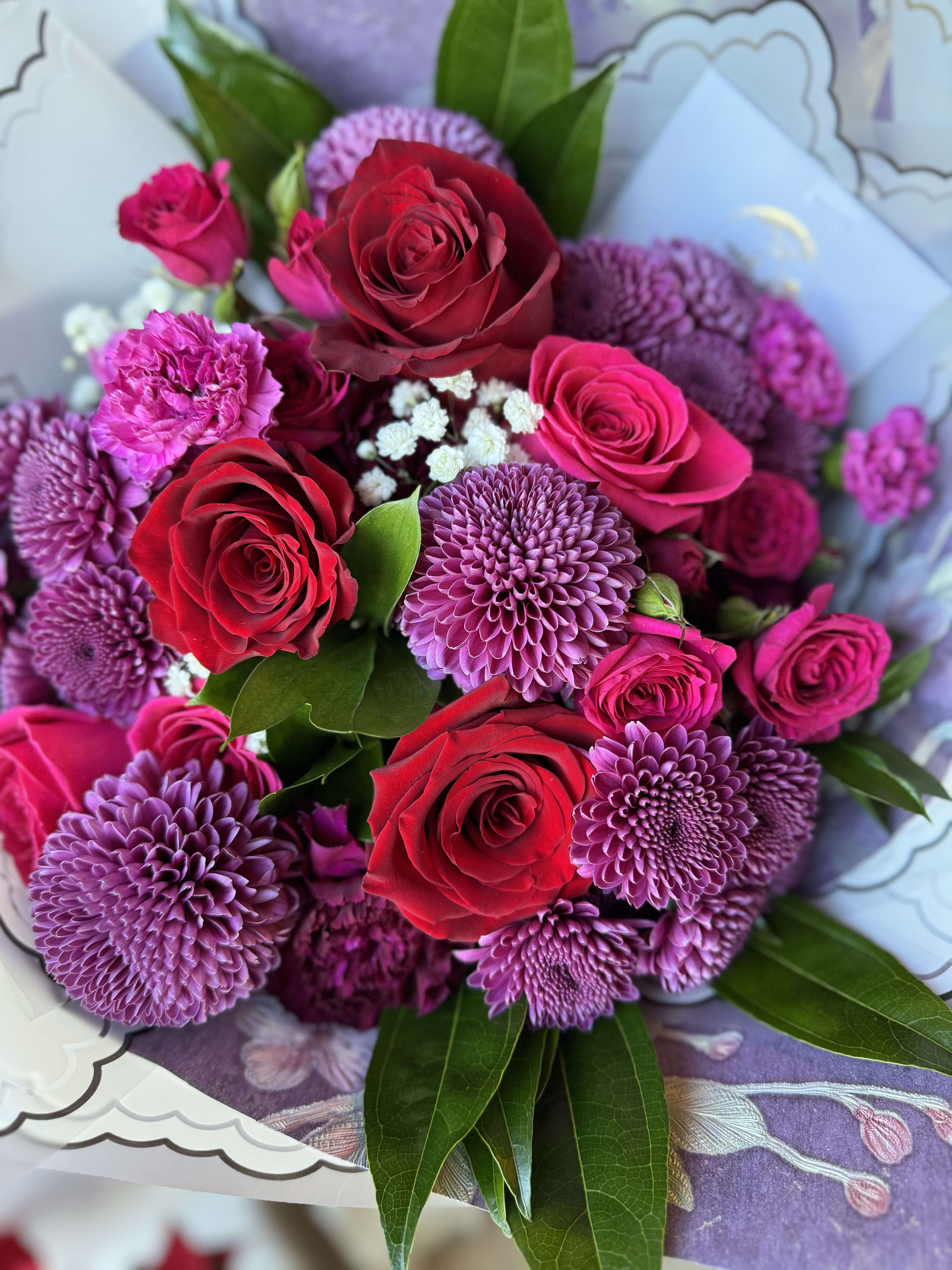 Eternal Bloom Bouquet - Elegant and enchanting, the Eternal Bloom Bouquet features a delicate harmony of Fuchsia and Red  roses, accent with different blooms. Nestled among fresh greenery, a touch of babybreath and wrapped in sheer white Korean paper, this bouquet captures a serene and graceful charm. It’s a perfect gift for birthdays, celebrations, or to simply say "you’re special" with subtle sophistication.