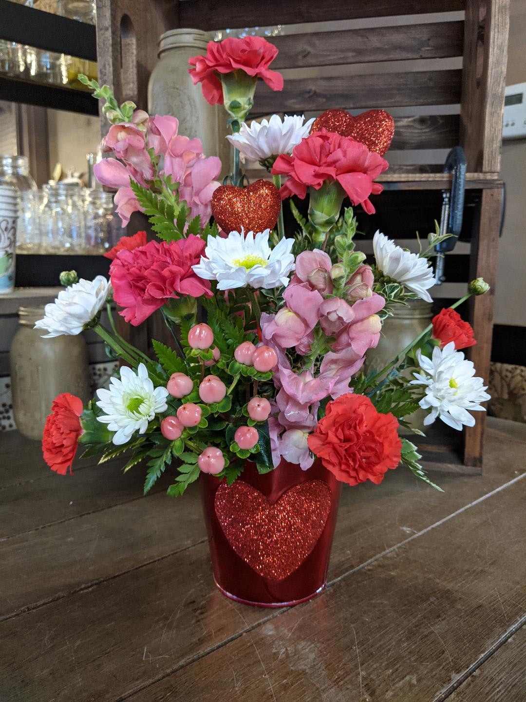 Be Mine Custom Design by Cold Spring Floral - Be Mine Bouquet is a Delightful Mix of Pink, Red and White with Carnations, Miniature Carnations, Mums and the Glitter Heart pick accent that matches the Glitter Heart on the Red Tin Container. All Flowers, Containers, Accents such as ribbon, picks etc. are subject to changed based upon availability.