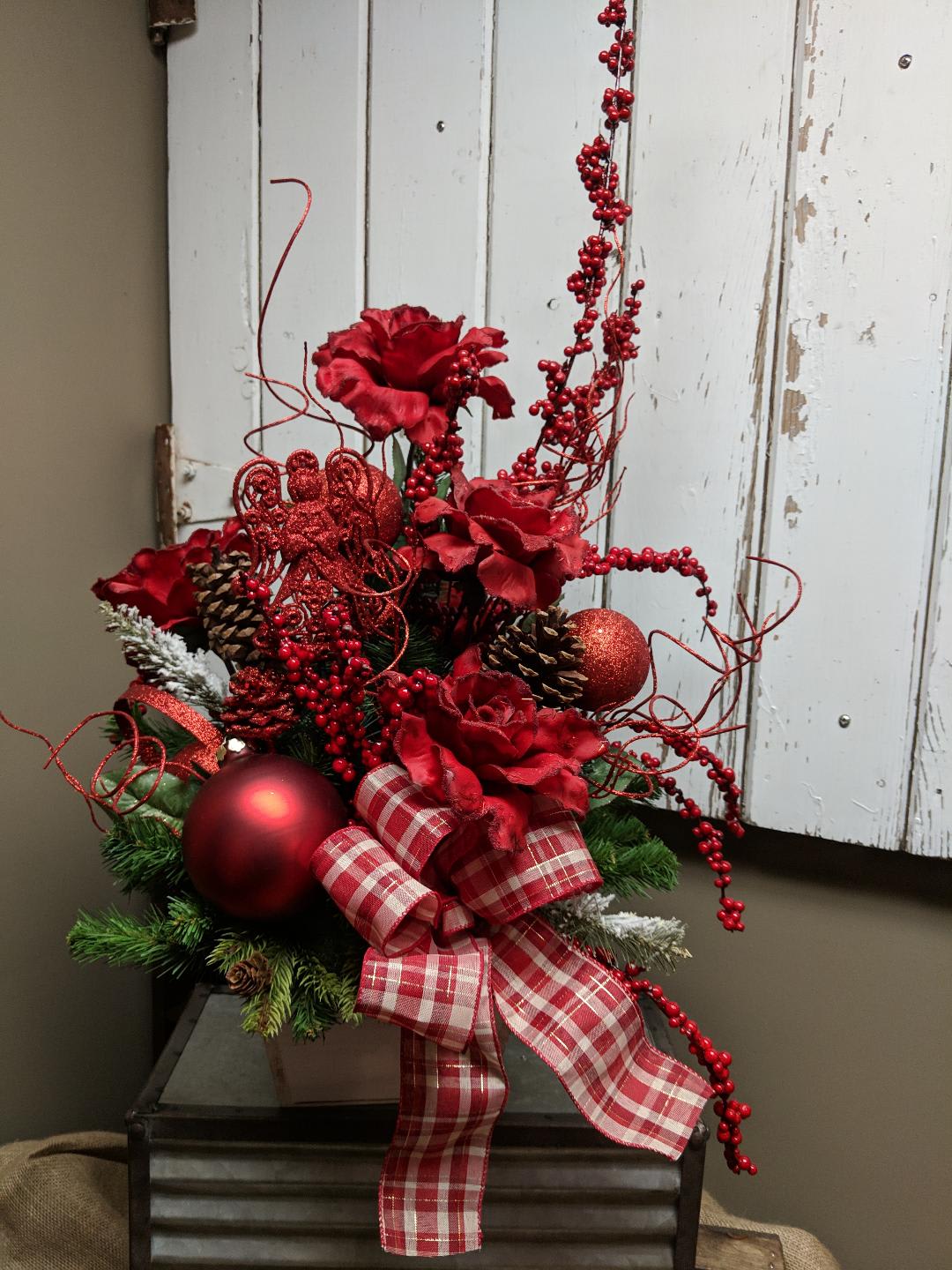 Christmas Bliss Artificial Silk Arangement Custom Designed by Cold Spring Floral - Christmas Bliss is an Artificial Silk Arrangement made from Red Roses, Red Berries, Bulbs and natural Pinecones.  Arranged with your entertaining in mind with an assortment of artificial greenery in a  wooden container.  Exact flowers, colors and accents of each Custom silk arrangement can vary to availability and because they are made to order. This beauty is another example of the Holiday cheer delivered locally by Cold Spring Floral.  Please call us so we can custom design one for you!