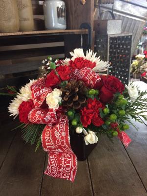 Deck The Halls  - This fun and festive arrangement has just the amount of red, white, and green flowers season has to offer This arrangement includes holiday greens, pinecones and berries. 