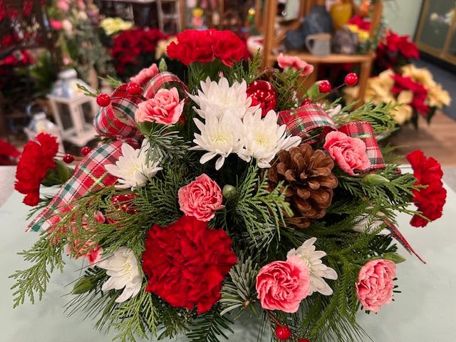 Holly Days Centerpiece (HDC) - A smaller round centerpiece or fresh arrangement. We fill the arrangement with colorful Christmas colors such as Red Carnations, Red Roses, white mums and some festive trim.