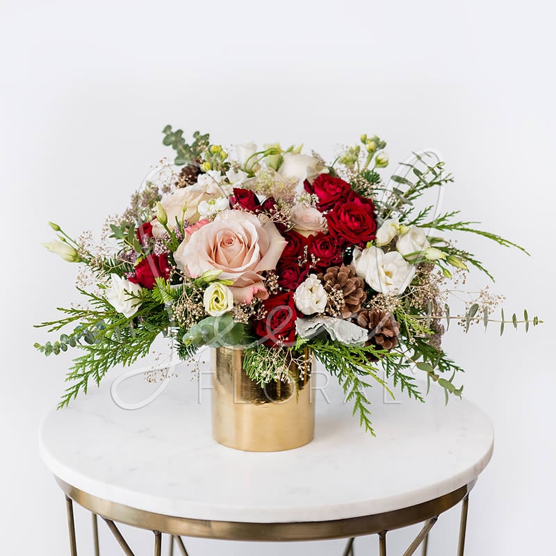 Starry Night - She has a bit of added sparkle &amp; just right amount of glam! Festive seasonal blooms in Reds, Nude, White, fresh holiday greens, pine cones &amp; accents of champagne gold babys breath featured in our gold ceramic vase.