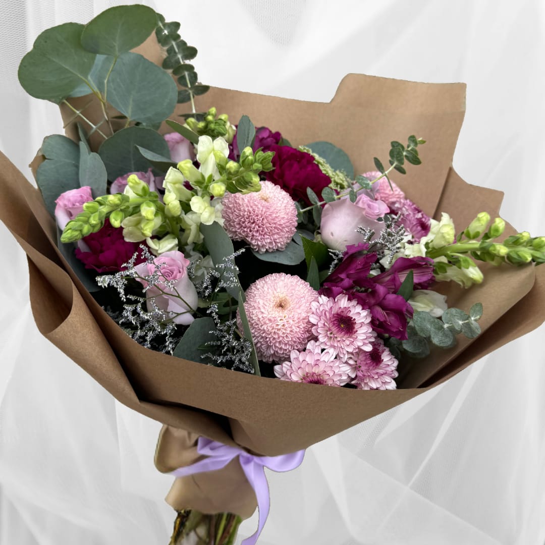 Violet Delight - Hand held bouquet of mixed purple florals with filler, brown paper wrap.