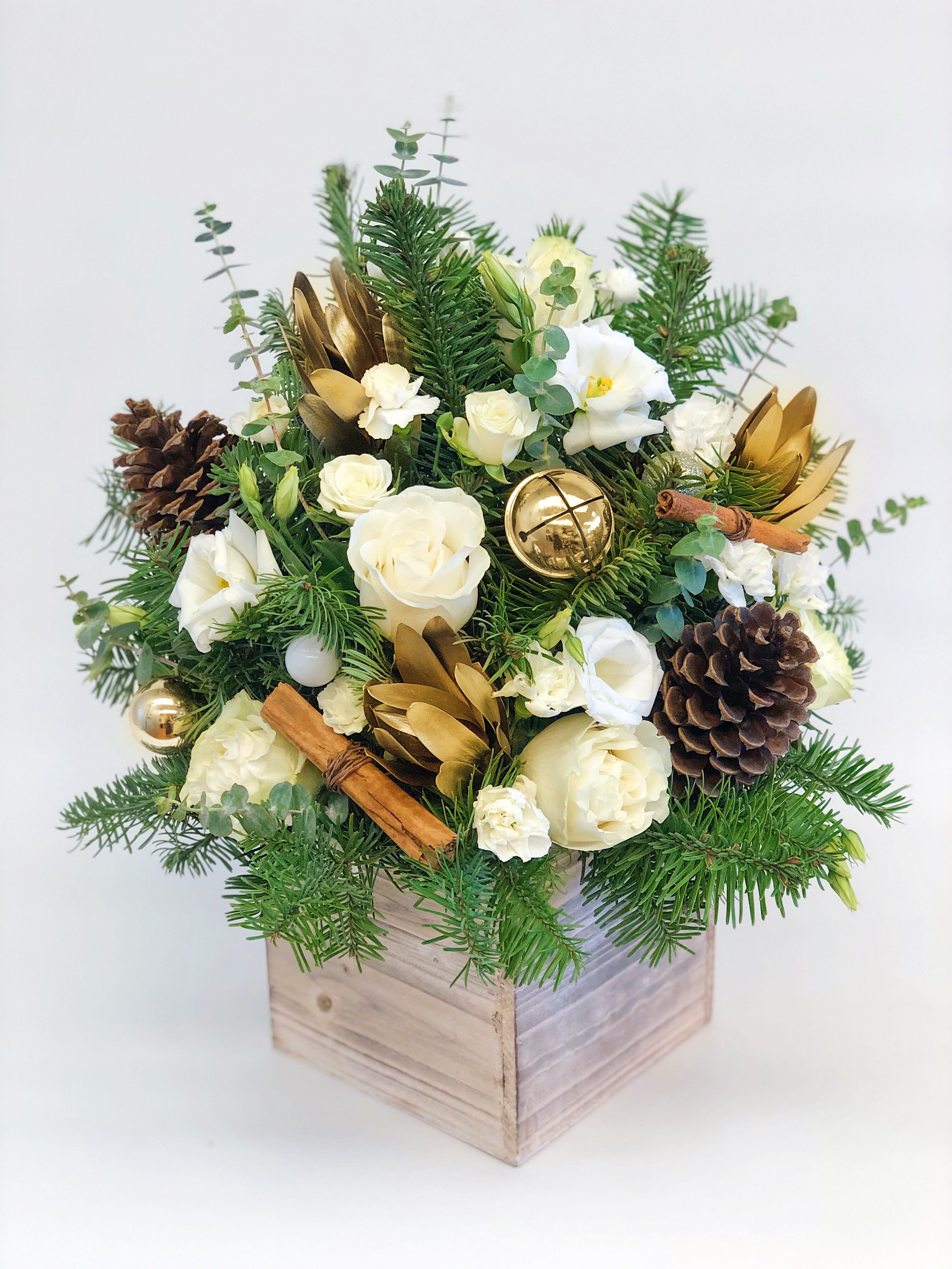 Gold and White winter arrangement tall in a wood box - If You want bouquet with a twist, choose our flower boxes. We have wood boxes for rustic looking arrangements, or hat boxes for a more elegant look. It’s a beautiful and convenient way. Flowers in boxes don’t need vases. That makes it perfect for transportation and keeping flowers hydrated and secure. Arrangement size approximately 18&quot;x12&quot;
