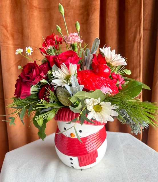 Snowman Smiles - This keepsake jar is perfect for gifting, decorating a desk or kitchen counter, or adding a cheerful touch to any winter celebration. This snowman brings smiles wherever he goes! Overflowing with vibrant red roses, winter greenery, soft whites, playful berries, and seasonal textures, this design captures the magic and warmth of the holiday season. 