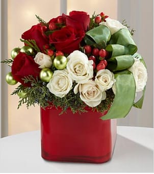 The Merry &amp; Bright™ Bouquet - The Merry &amp; Bright™ Bouquet is a charming display of seasonal cheer. Vibrant red roses, white spray roses, red hypericum berries and assorted holiday greens create a stunning look with green glass balls and green taffeta ribbon nestled within the arrangement. Arranged in a red glass cube vase, this bouquet is guaranteed to make their holiday both merry and bright. This bouquet is approximately 12&quot;H x 10&quot;W. Your purchase includes a complimentary personalized gift message.