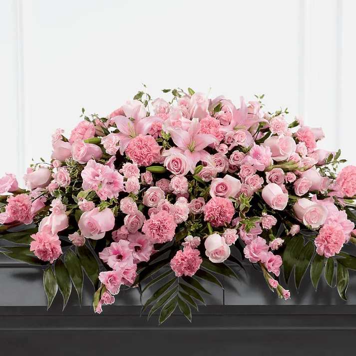Garden of Comfort Casket Spray (Standard) - Honor a loved one who was sweet, compassionate and charming with our Garden of Comfort Casket Spray. It is crafted with care and composed of a refined array of pink lilies, gladiolus, roses, carnations and accents of luscious greens. This arrangement is a touching tribute that beautifully expresses your love.  Details 48"h x 38"w
