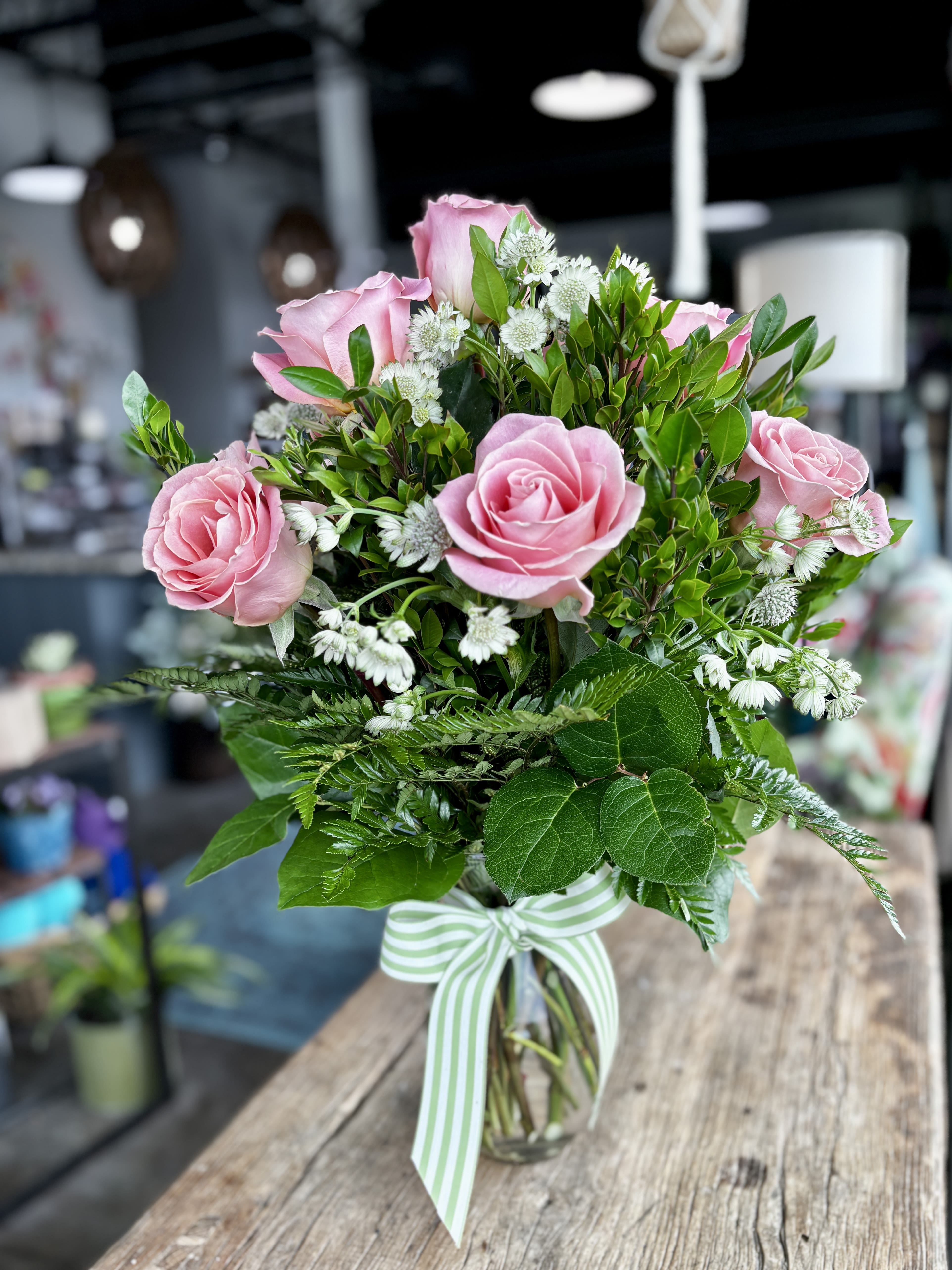 Traditional Dozen in Pink - Show someone how much you care with a dozen pink roses! Premium long stemmed roses are designed beautifully with lush greens. Upgrade to 24 or 36 roses to really spoil them!  Vase height is 10.5 inches.
