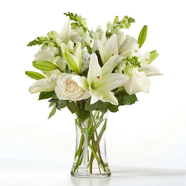 Eternal Friendship Bouquet - An exuberance of bright and beautiful white blossoms provides an exquisite way to deliver your expressions of sympathy and comfort. This life affirming tribute combines white roses, snapdragons and Asiatic lilies accented by lush greens arranged in a clear glass 8" vase. An excellent choice for a wake, funeral service or for sending your condolences to the home of grieving family or friends.  Details Approx. 21" H x 19" W