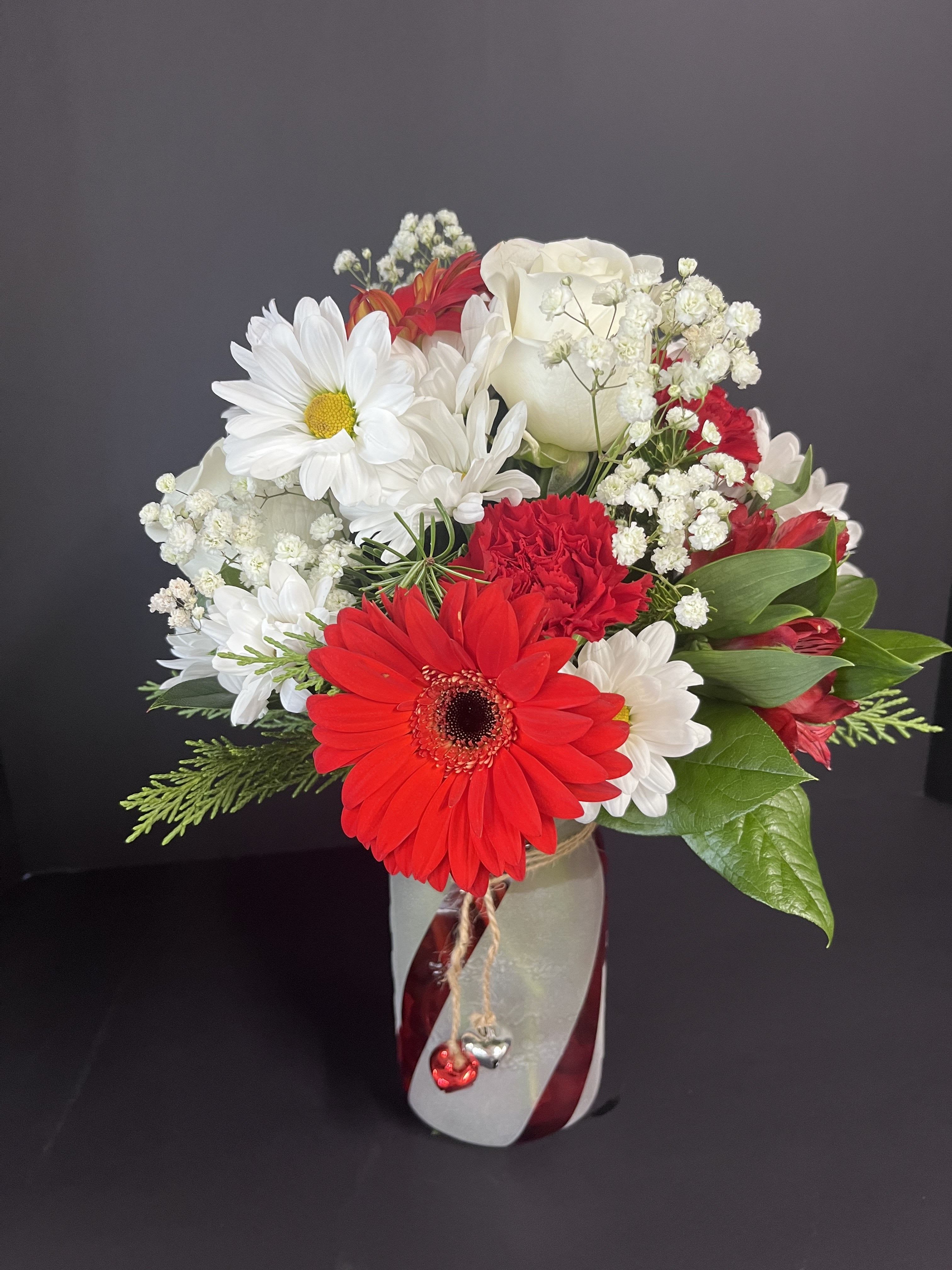 Candy Cane Bouquet - This Bouquet is created using our beautiful red and white blooms of the season, in a red and white striped vase.