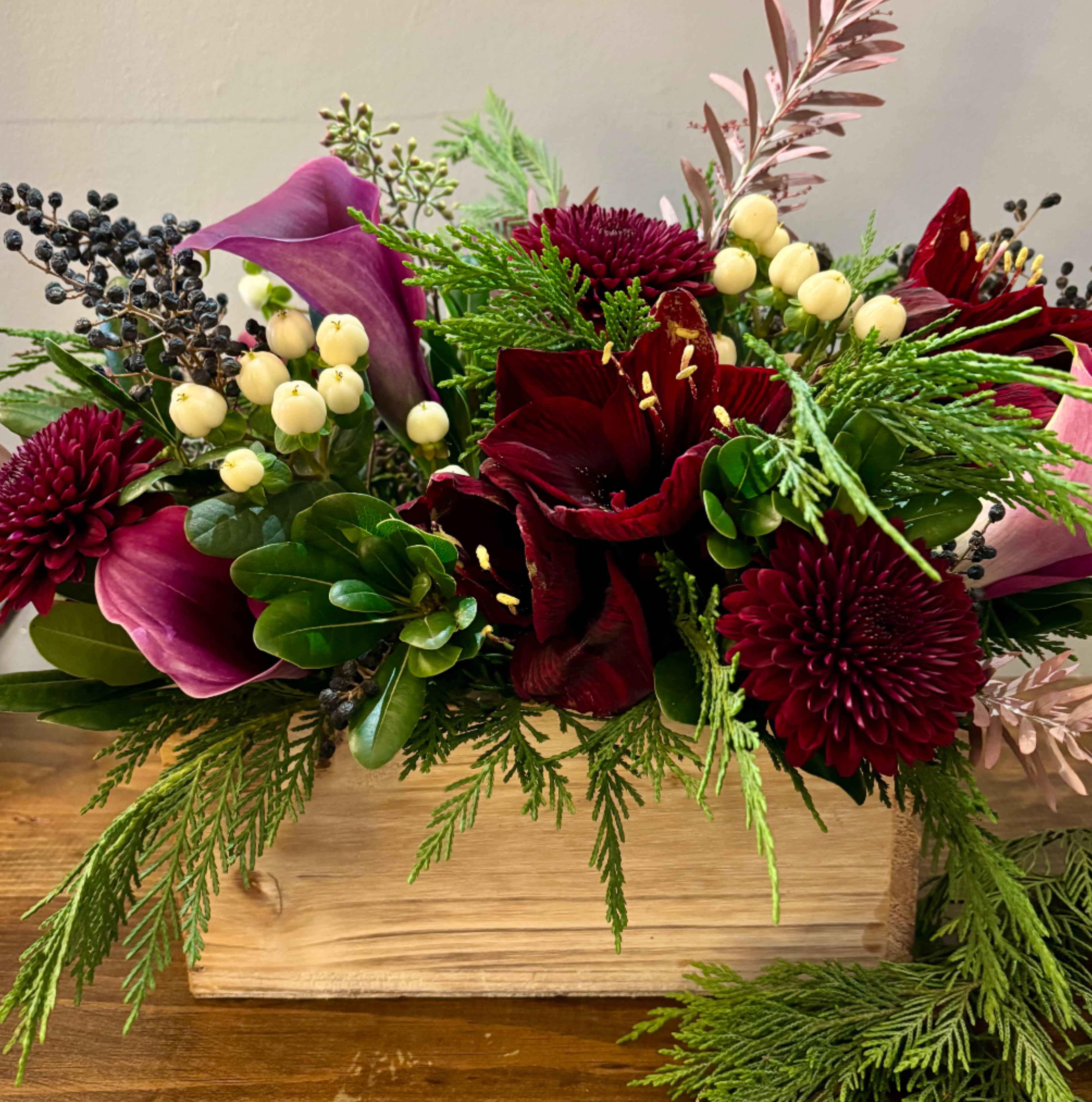 Sugar Plum - A festive celebration box pf classic and seasonal blooms. Filled with Amaryllis, calla lilies, berries, pom flowers and greenery. Perfect centerpiece for holiday gatherings with friends &amp; family..   Every effort will be made to recreate your chosen design. Please note that from time to time due to product availability and quality we may need to make substitutions. We will make sure to keep the original design in mind when making substitutions.