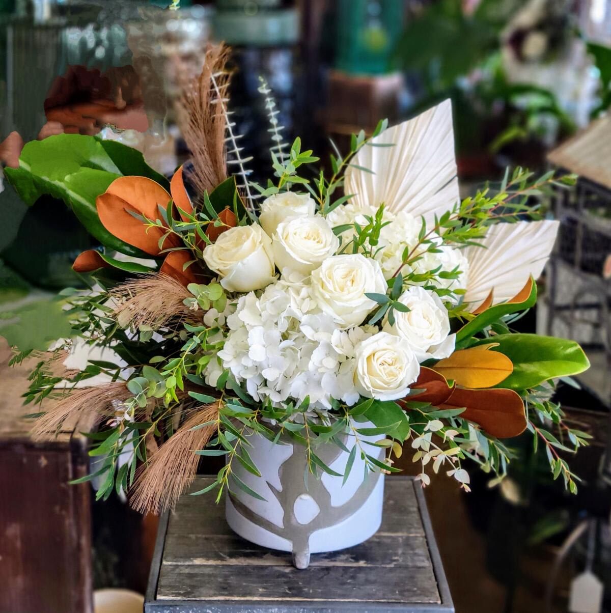 Magnolia - An all-white arrangement accented with magnolia and eucalyptus.