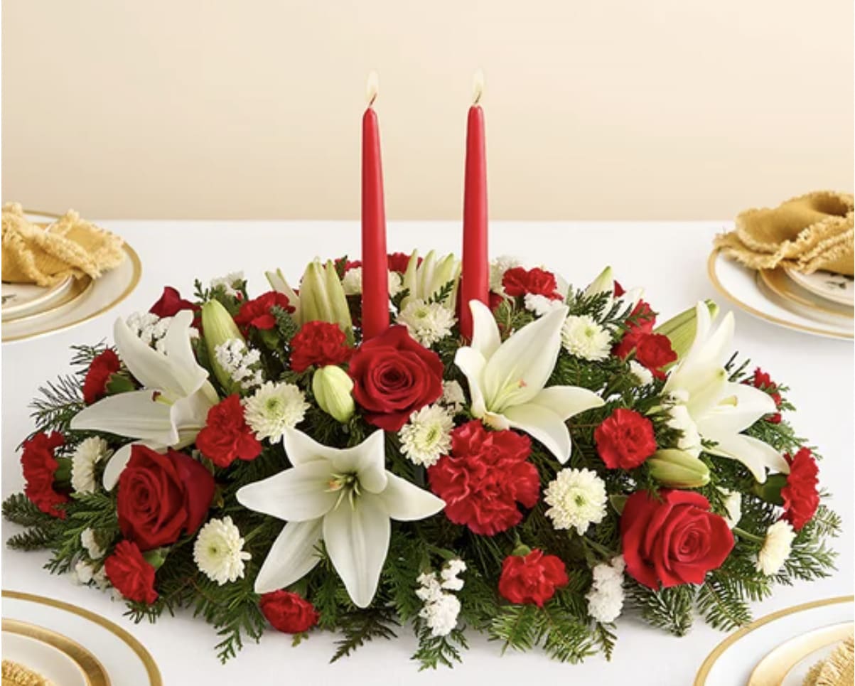 Christmas Centerpiece  - Our classic table arrangement is an idyllic centerpiece for your Christmas celebration. Beautifully designed with long-lasting blooms in seasonal colors, this fragrant gathering features red taper candles to cast a warm, inviting glow throughout the holidays.
