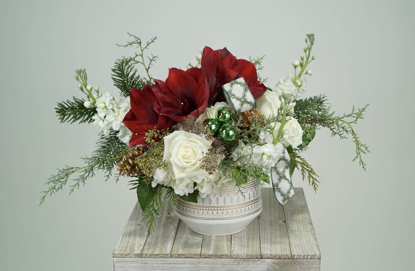 Jingle Bells  - This elegant but classic deign is something out of our favorite holiday movie. Complete with amaryllis, white rose, gold pine cones, gazing ornaments, and stock. The greens will bring you cheer around the home with their wonderful smell.  