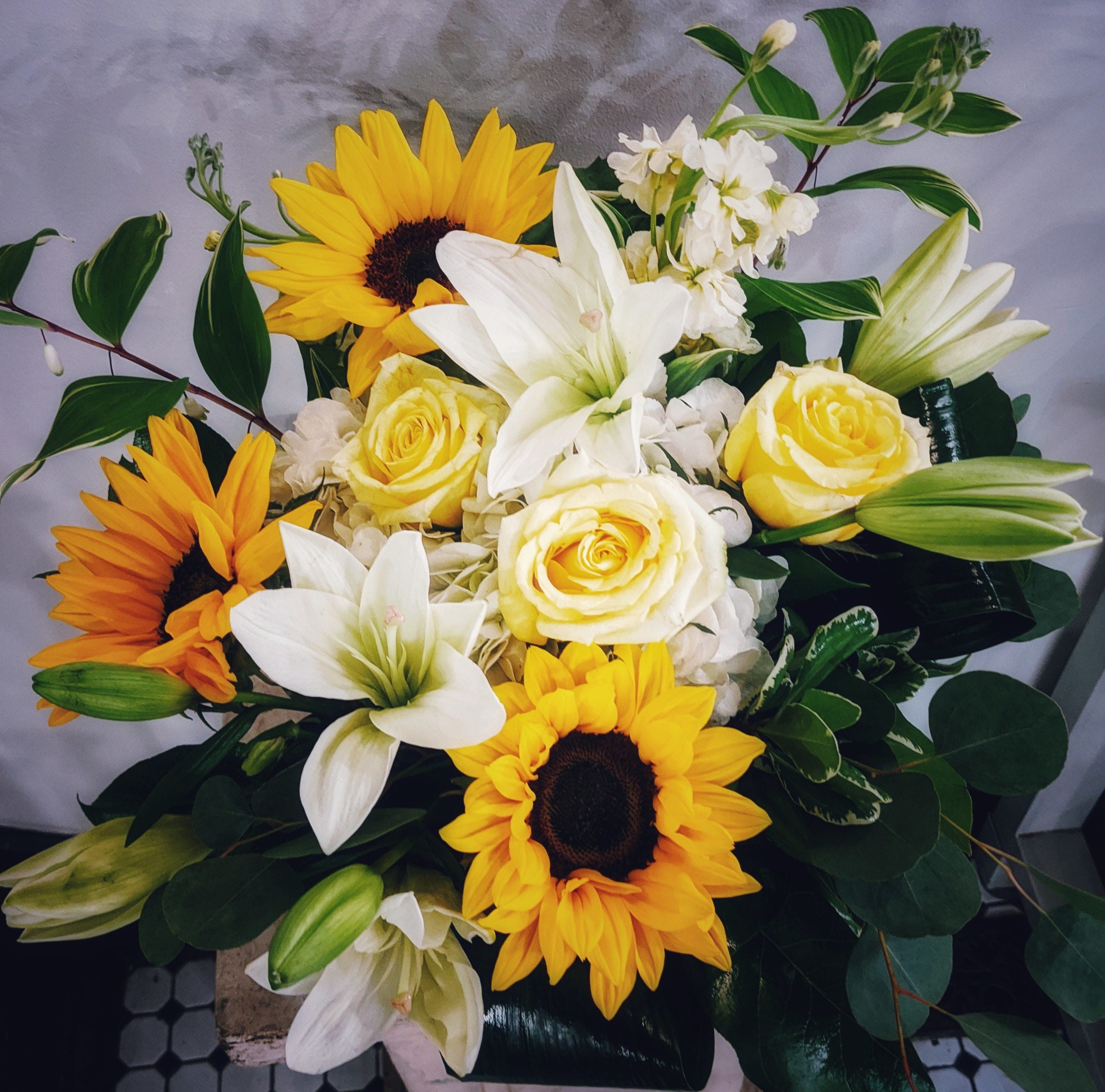 So Sunny - Beautiful sunflowers, arranged with lush garden flowers in a low compact design, are sure to bring sunshine to someone's day.  Wither for a celebration, or &quot;just because&quot;, this arrangement will result in a beaming smile.