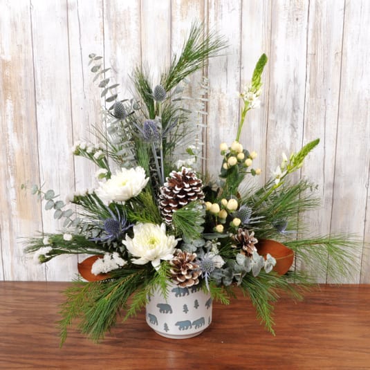 Polar Bear Hugs - Keepsake bear container, filled with wintery neutral blooms in blue and white with pinecones and wintergreens.