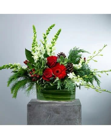 Winter Gardens  - Bring the beauty of the colder weather inside. Winter Gardens II is sure to warm the hearts of all. Snapdragons, dendrobium orchids, roses, gerbera daisies and and more accents designed in a clear glass rectangle container appropriate for a dining room table or kitchen island. Approximately 30" W X 20" H   All prices in USD ($)  Standard  DGTMF-1248