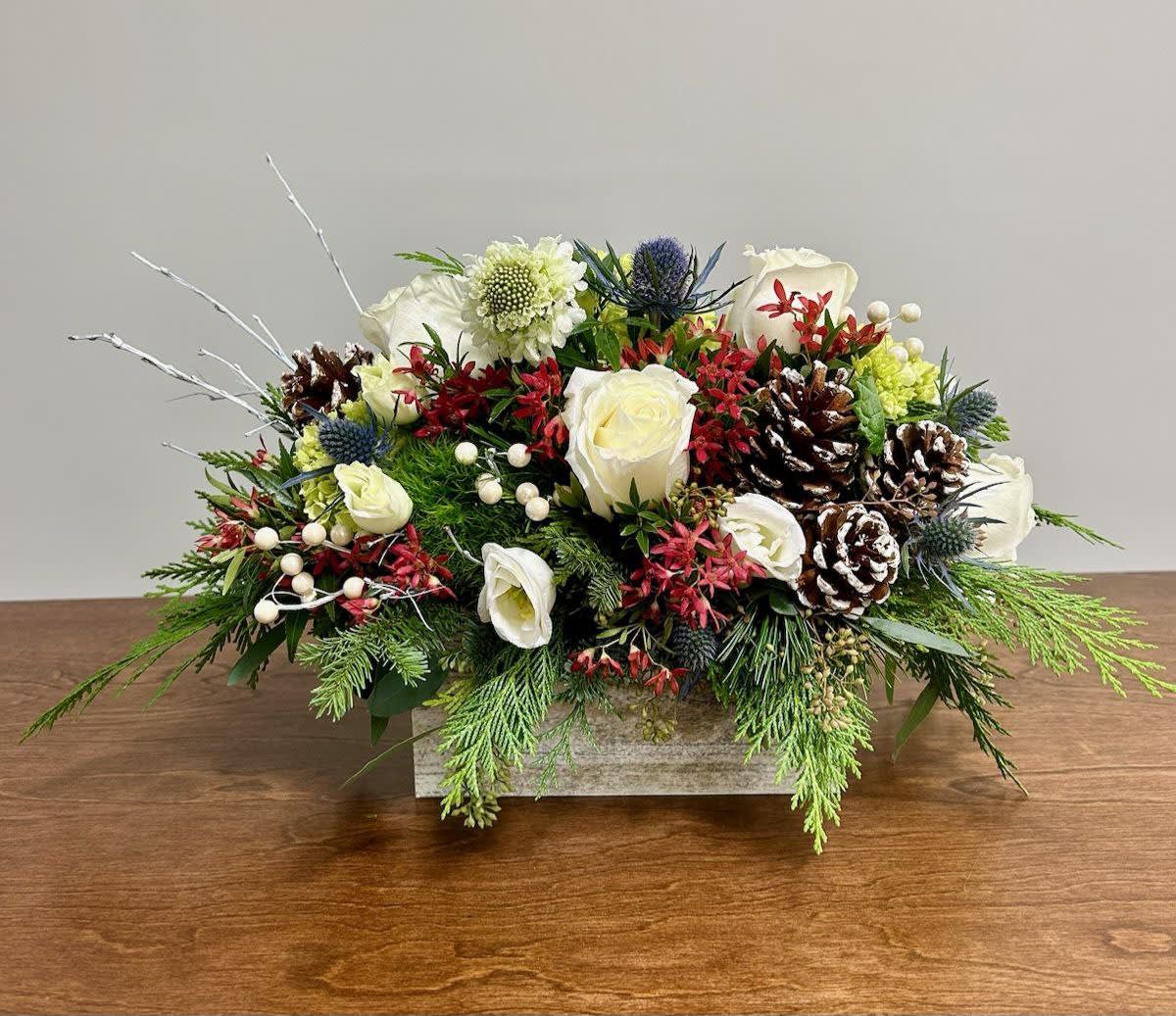 Countryside Christmas - White roses, mini green hydrangea, dianthus trick, and pinecones make up this Countryside Christmas arrangement. Together, these elements create a delightful blend of festive cheer and rustic charm, perfect for bringing the spirit of Christmas into any home.