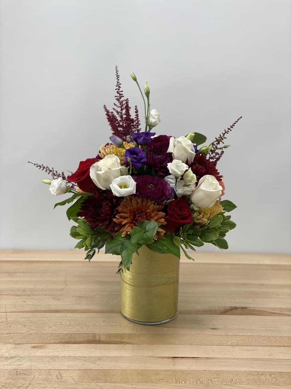 GOLDEN FALL - A combination of fall color flowers like ranunculus, chrysanthemum, and rose, in a tall glass vase covered with gold ribbon. This arrangement is a perfect thanksgiving or Christmas gift for your everyone. 