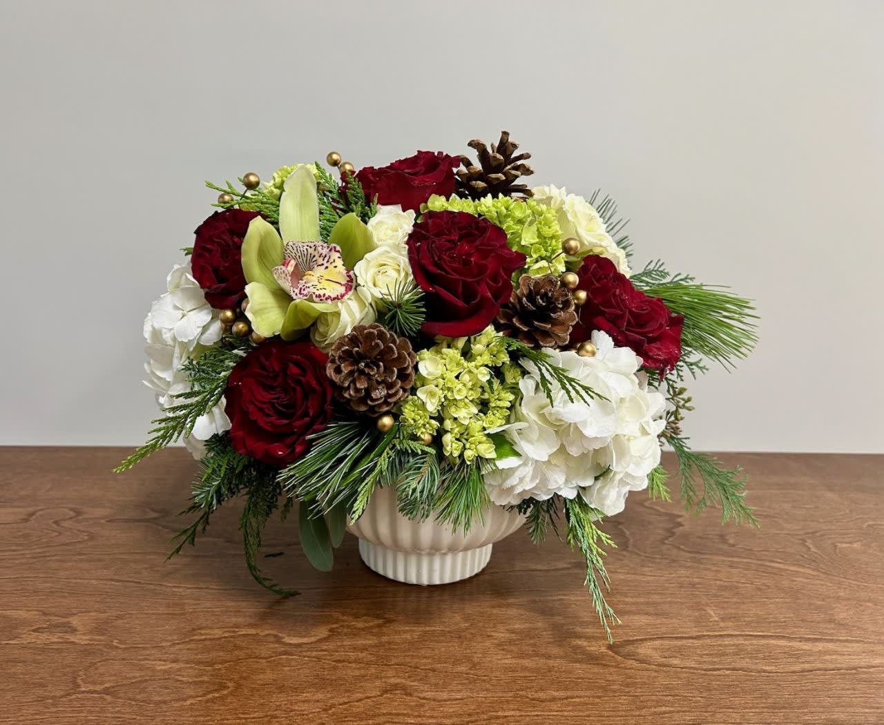 Heart Song - The Heart Song arrangement is a harmonious symphony of love and nature. The rich hearts roses, pure white hydrangea, refreshing mini green hydrangea, and exotic cymbidium orchids come together in perfect balance. Perfect for creating a warm and inviting atmosphere for the holidays!