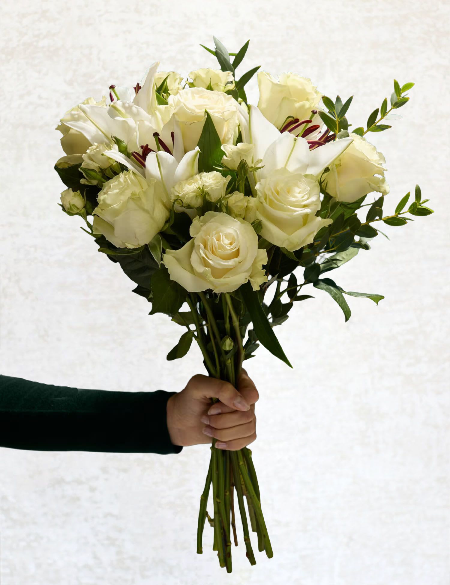 Pure Serenity - Elevate any space with the timeless elegance of the Pure Serenity Bouquet. This stunning arrangement showcases the classic beauty of white roses, delicate white spray roses, and graceful white lilies, all accented with the fresh greenery of eucalyptus. Perfect for expressing sentiments of love, peace, or celebration, this bouquet exudes sophistication and tranquility. Whether it's a thoughtful gift or a way to add serenity to your home, this arrangement is a true embodiment of understated charm.  What's included?  White Roses, White Spray Roses, White Lilies, and Eucalyptus.