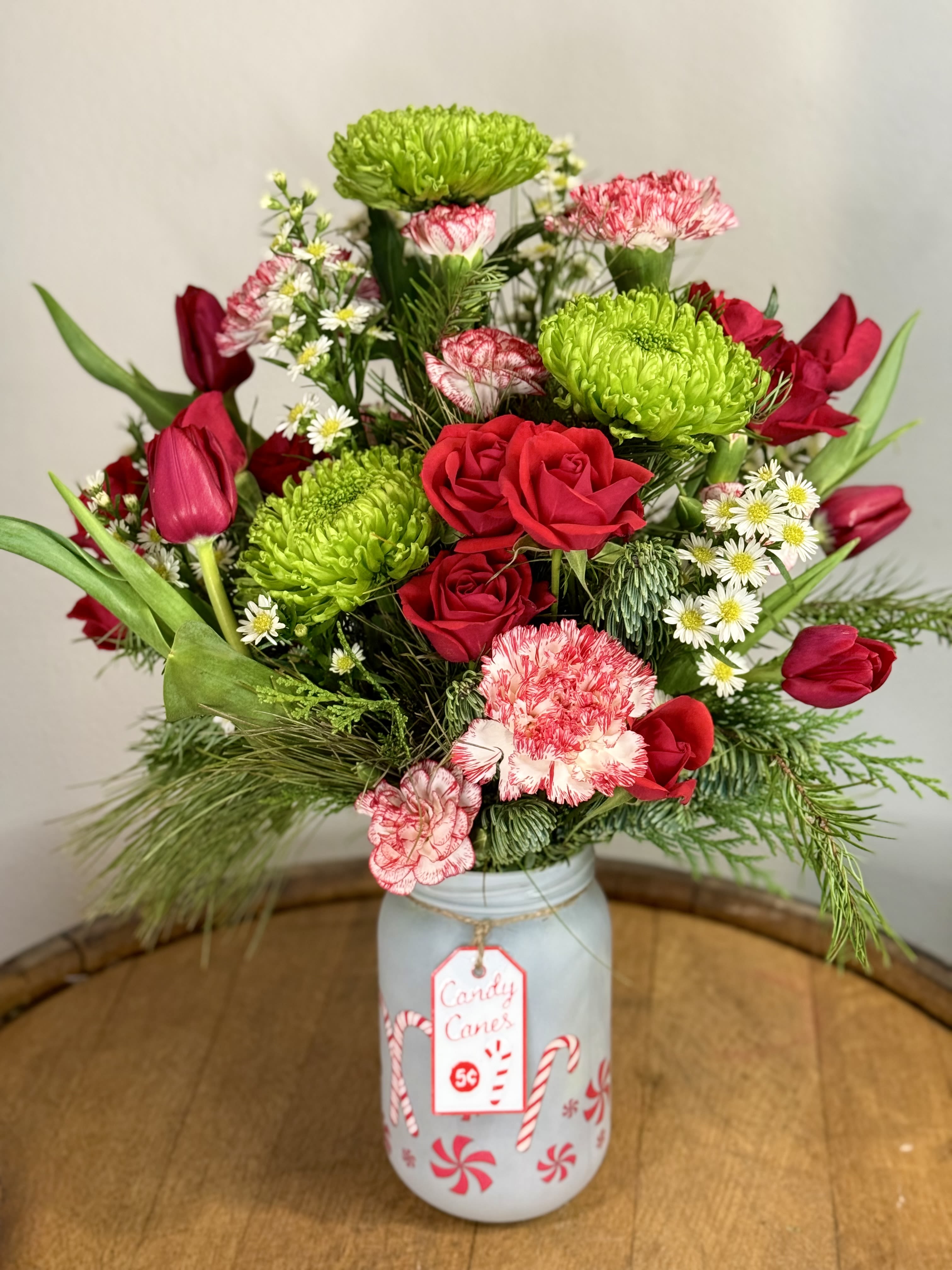 Santa's Sweet Surprise - This playful, candy-cane arrangement is bright, festive and perfect for anyone's Holiday table.