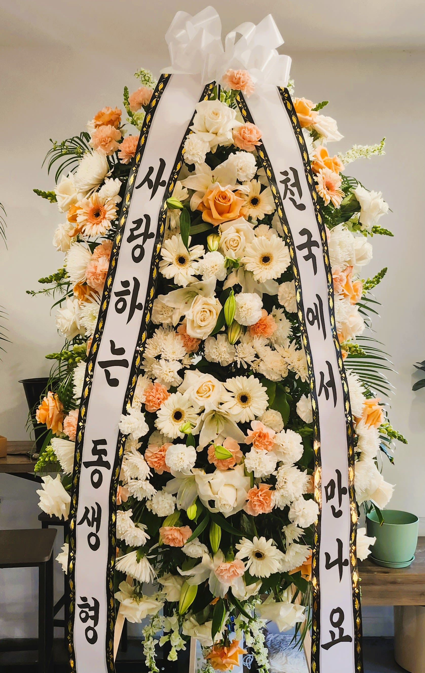 White &amp; Peach Standing Spray - Standing Spray for funeral. White and Peach Mix 7 or 7 1/2" Tall size and wide width.  You can choose what you want color.  Please memo to us when you order it.  We can attached a ribbon as photo also give us what you want to say two line messages for it. 