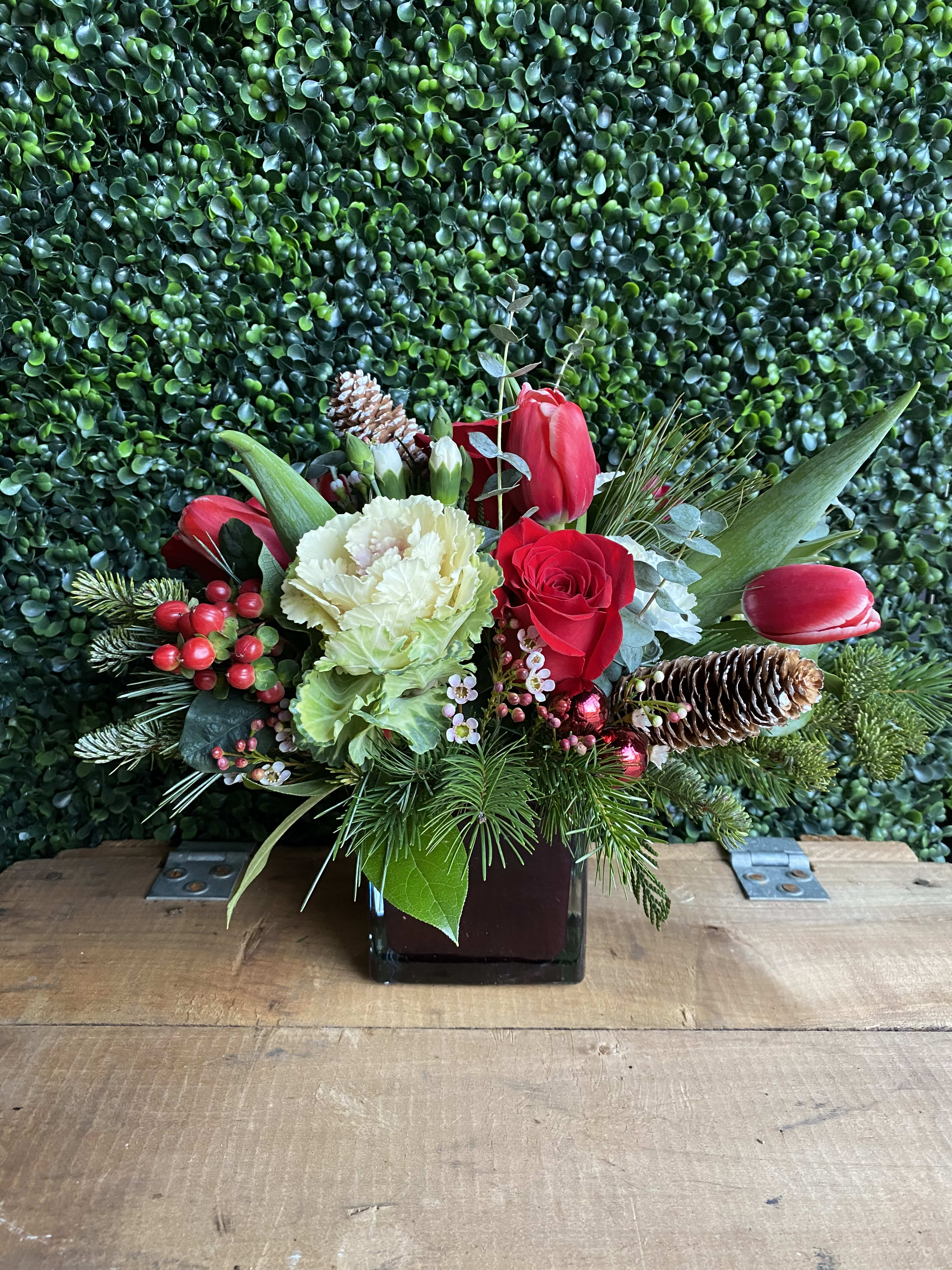 Kale Festive - Kale white, roses red, hypericum, pom poms, wax and mini carn.  winter greens, pine cones in a glass vase.  Delivery minimum is $50.00 Our DELIVERY SERVICE IS TILL 3 PM We cannot guarantee requests for a specific time of delivery. There might be flower substitutions, due to low supply of certain flowers. However, we do our best to provide you with the same look and feel of the arrangement. Our main goal is to always give our customers quality flowers and service. To make sure that you get the exact same flowers, ordering a few days ahead of desired delivery date is key.