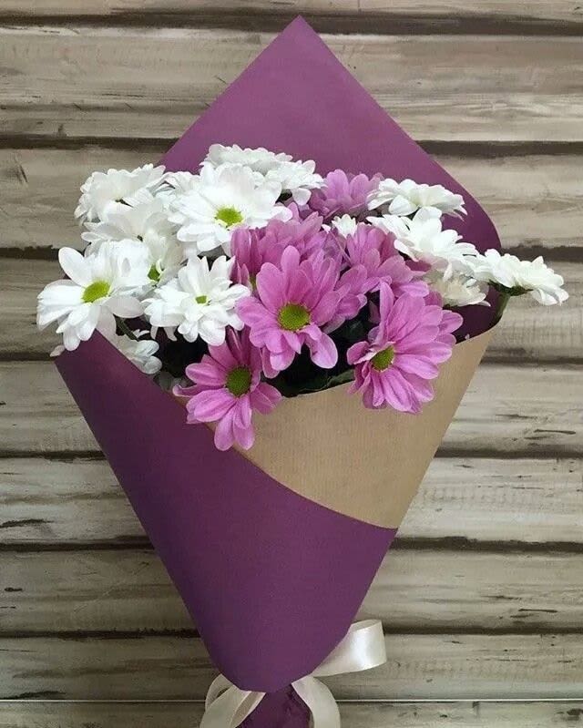 Ramo Dulce Armonía -  Descripción del arreglo:  El Ramo Dulce Armonía combina la frescura de las margaritas blancas con el encanto de las margaritas lilas, creando un bouquet suave, juvenil y lleno de luz. El envoltorio en tonos kraft y púrpura complementa perfectamente los colores del ramo, dándole un estilo moderno, sencillo y elegante.  Es un detalle ideal para transmitir cariño, agradecimiento o alegría en cualquier ocasión.Este diseño SIEMPRE requiere un mínimo de 10 días de anticipación, ya que se realiza únicamente bajo pedido para garantizar frescura y disponibilidad.