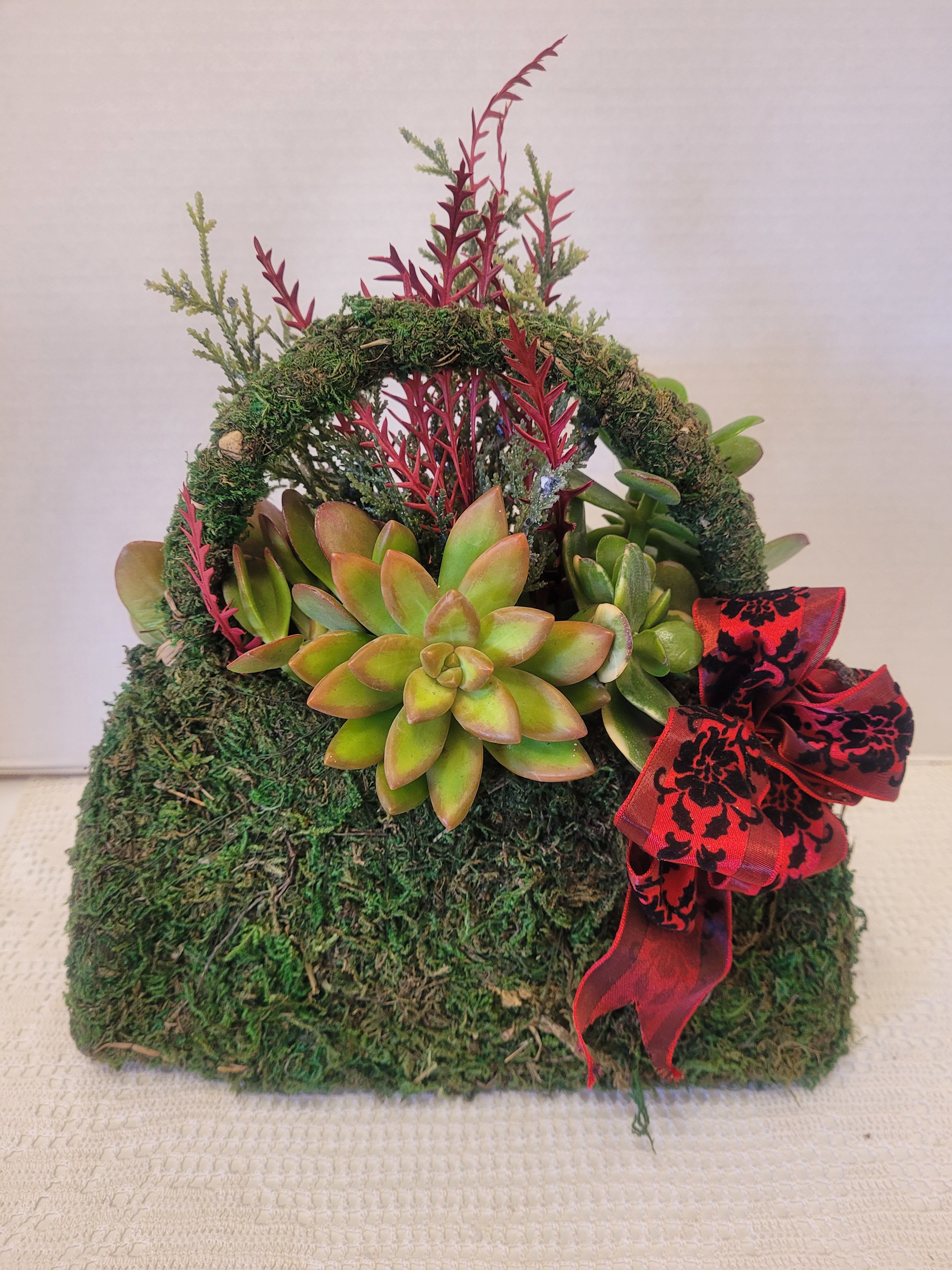 Moss Purse - Everyone deserves a moss purse stuffed with succulents and varied holiday embellishments. 