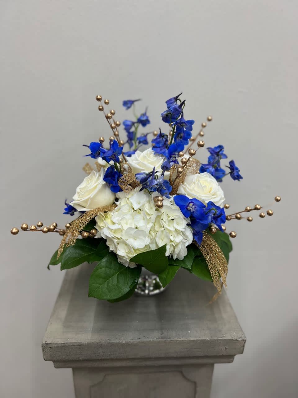 Sapphire, Gold &amp; Silver Bouquet - Bold sapphire blue delphinium arranged together with lush white hydrangeas and soft gold millimeter balls in a silver mercury pedestal bowl. Perfect piece to decorate your table, house, office, and anything else you can think of. 