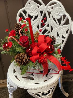 Sleigh Bells Ring  - This decorative sleigh is filled with Christmas greens, the best red flowers of the season, berries, pinecones and special holiday touches. 
