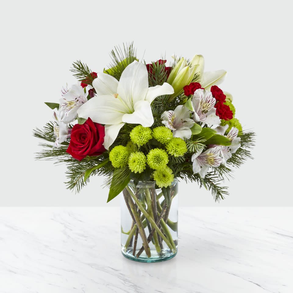  Christmas Spirit Bouquet - Whether you’re sending season greeting’s from across the country or welcoming guests to your home, our Christmas Spirit Bouquet shares every message of warmth and cheer. Filled with a collection of lilies, roses, hypericum berries and alstroemeria, this arrangement helps make every occasion beautiful. Give this to your loved ones, or as a gift to yourself, to deck the halls during the holidays.