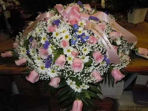 C13 Casket Spray - A mixture of white daisies, pink roses,  purple iris, purple statice, greens, and baby's breath.    Banner - $15.00 + extra  Substitutions may apply, pending flower availability.