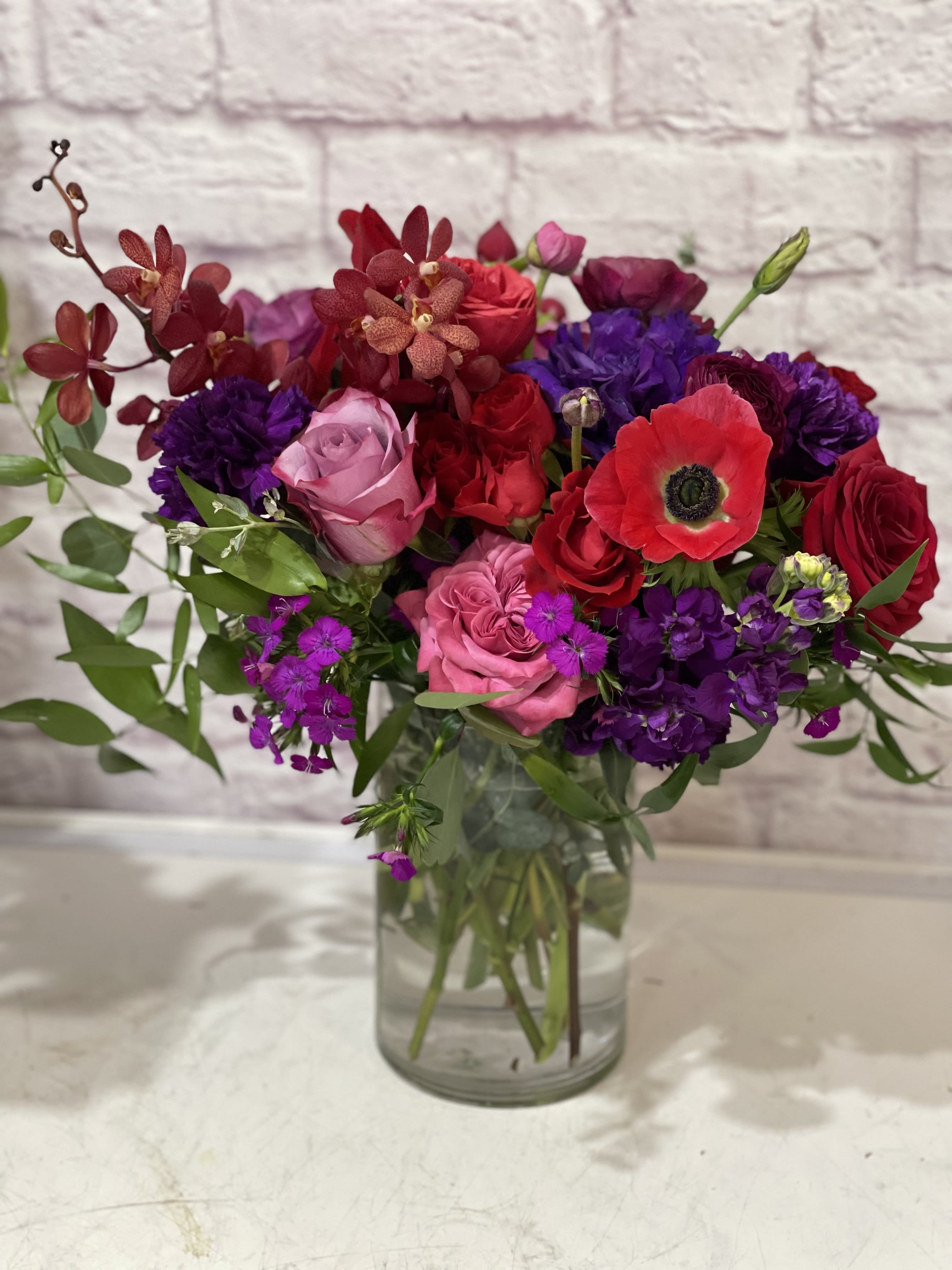 Amoré - Unique, bright and bold. Luxury reds and purples, featuring piano roses and jewel tone anemones.   Perfect for birthdays, &quot;get well soon,&quot; new baby, romantic gestures, and &quot;Thank you.&quot;   Available for delivery in Seattle, Bellevue, Shoreline, and surrounding areas. Available for delivery in all neighborhoods in Seattle including Magnolia, Ballard, Fremont, Downtown, Queen Anne, Crown Hill, U District, West Seattle, International District, Capitol Hill, Pioneer Square, Beacon Hill, Columbia City, Georgetown, etc. 