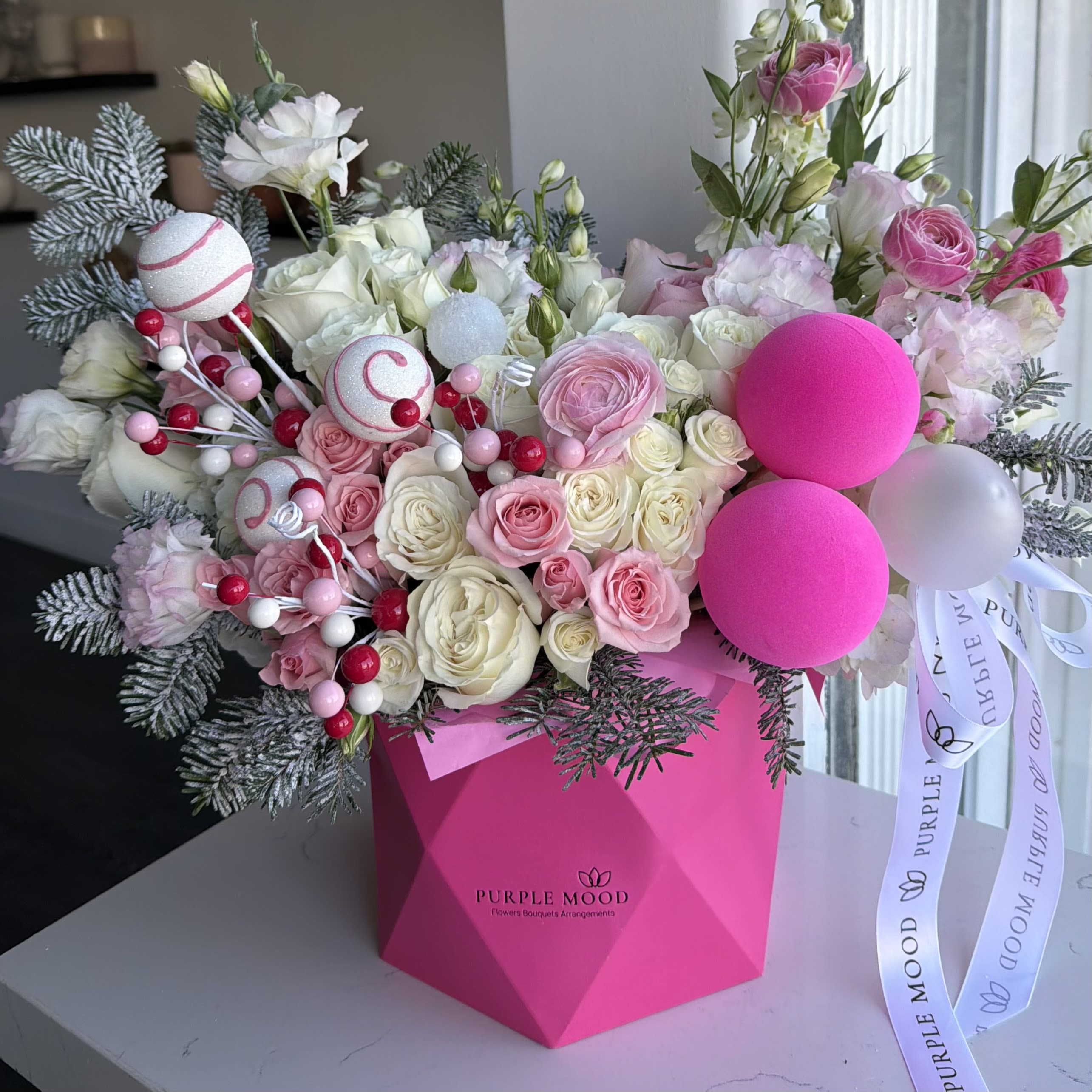 Candy Box - A sweet and festive winter arrangement bursting with soft pinks, creamy whites, and playful candy-inspired details. The Candy Box features premium roses, lisianthus, frosted evergreens, bright berry accents, and whimsical peppermint ornaments — all arranged in a bold hot-pink geometric box for a fun and modern holiday look.  Perfect for gifting, winter celebrations, or adding a cheerful pop of color to any space. Same-day delivery available across Los Angeles. ️