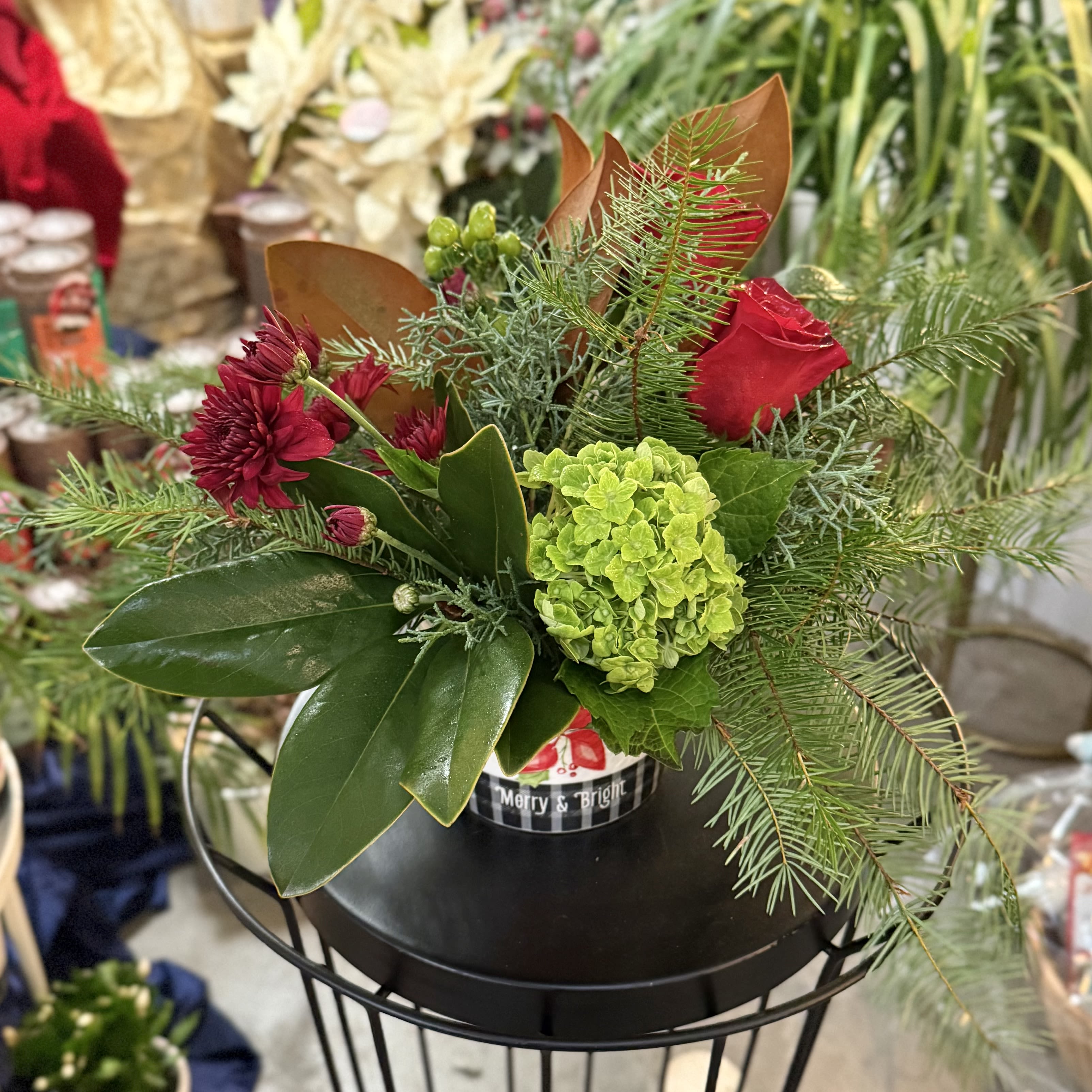 Merry and Bright Holidays - Filled with evergreens, magnolia, red roses and mums, and green hydrangea and berries, this is a delightful centerpiece all season long!
