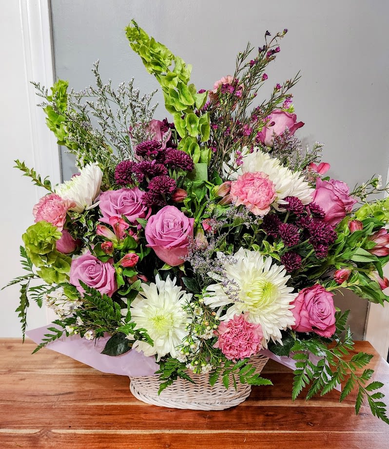 sweetheart Basket - This is a darling arrangement of fresh flowers in a white basket. Purple roses and white star flowers. pick carnations and deep purple daisies. 