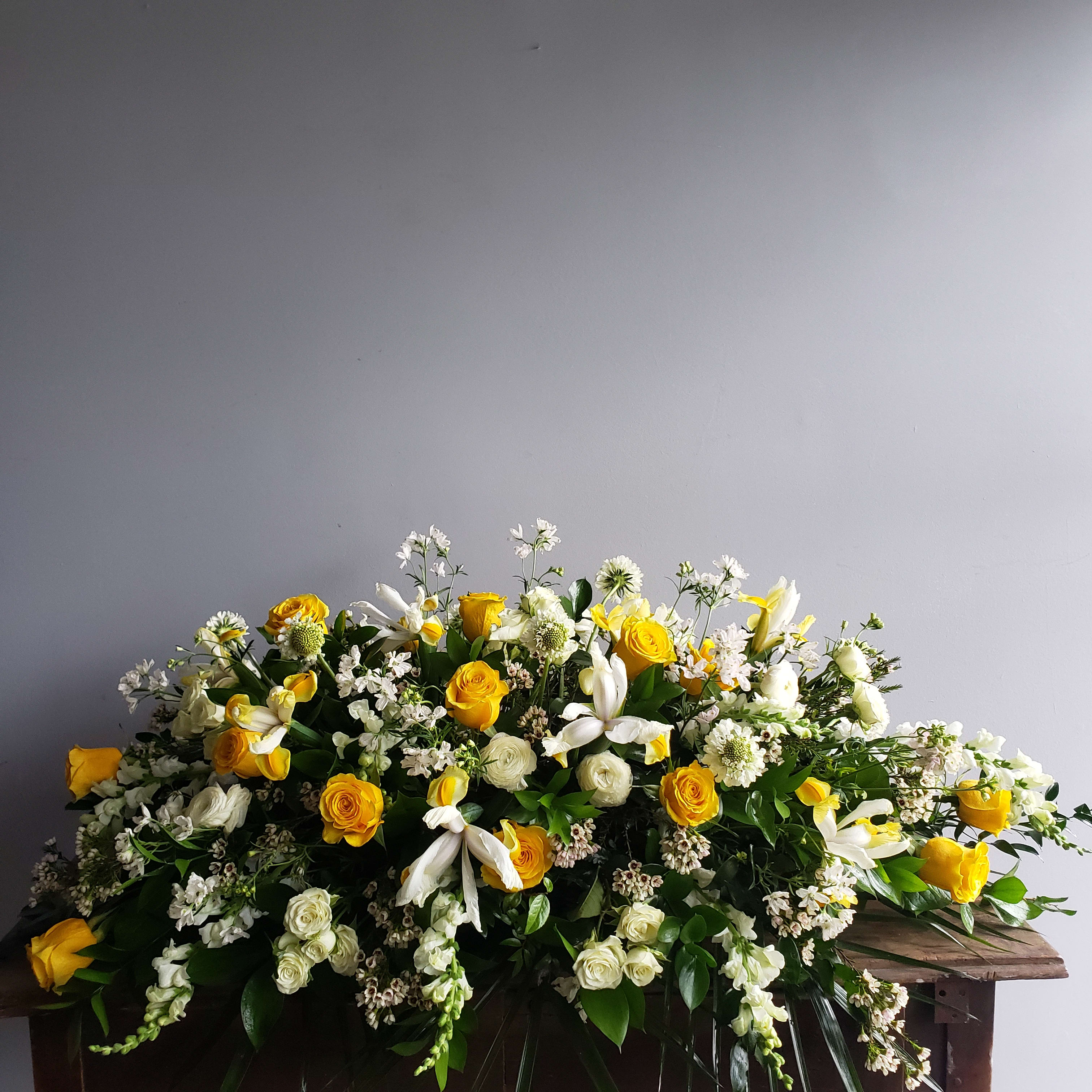 Full Casket Spray - This spray is overflowing with roses iris, greenery and other blooms.  Please specify desired colors.