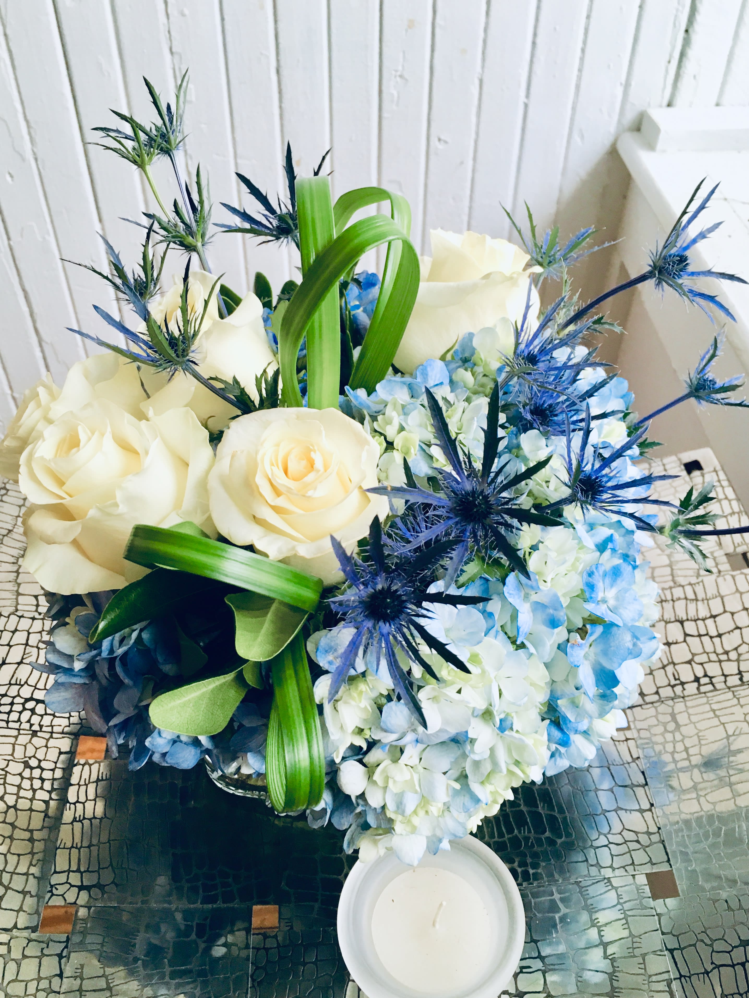 Blue Stars, Blue Sky.   A Floral Archist™ original. - Perfect for HIM! Natural shades of blue design. Blue hydrangeas, Blue thistle stars and softly scented baby powder white roses clouds. It also makes a perfect and elegant Congratulations, Happy Birthday, Welcome Home, It’s a Boy or Just Because expression. And of course, for the Gal who loves blue! Male appropriate or anyone who simply loves blue.    NOTE: Our flowers and greens are a gift from nature. It’s shade and depth might vary, design, aesthetic and value remains the same. In support of our efforts to aide in the preservation of our planet, PJf uses Fair Trade flowers, Plants, Upcycled and Recycled containers.  