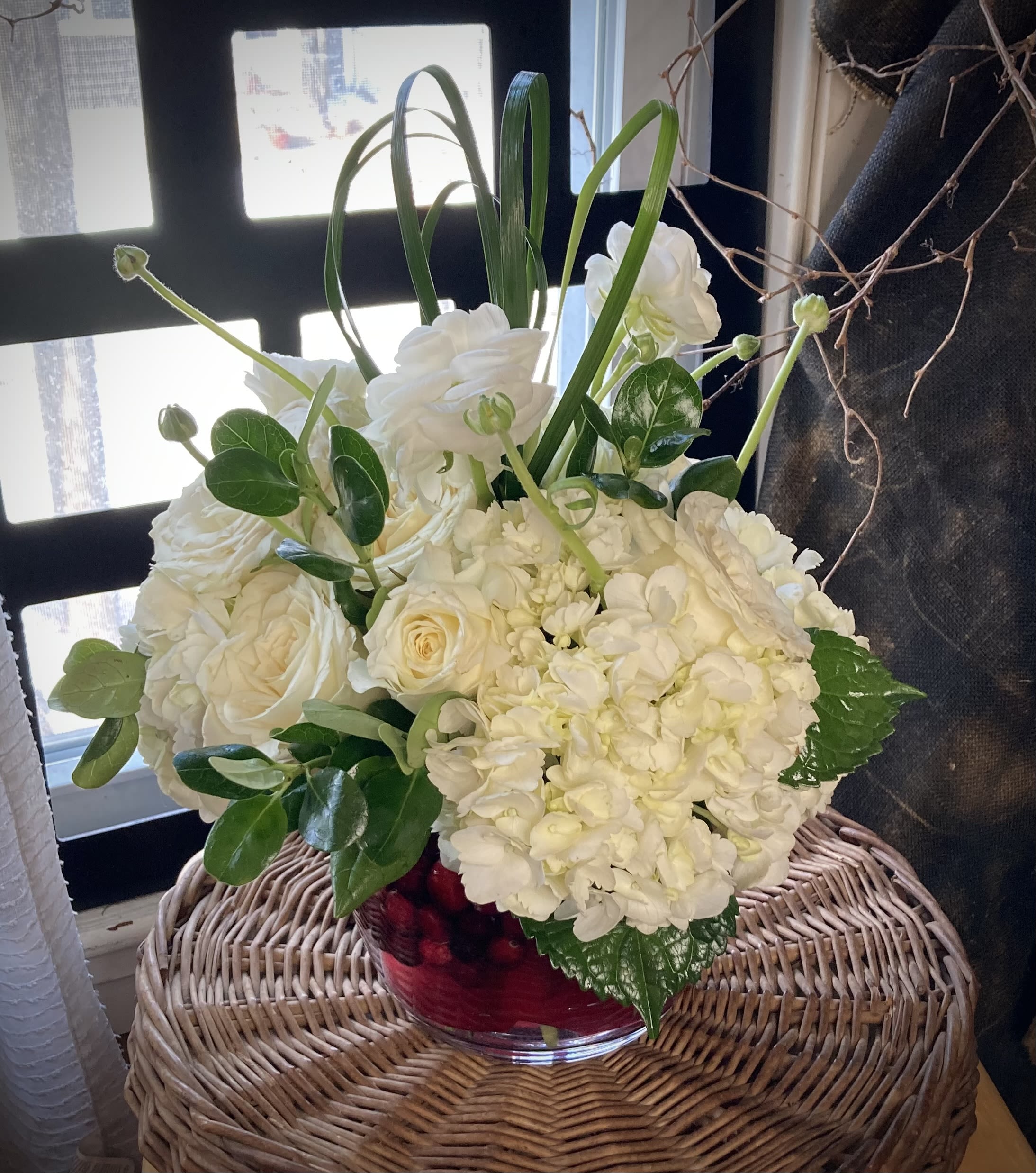 Pure Passion.  A Floral Archist™ original - This design says it all with one look! Pure as white flowers and Passionate as the different shades of red found in our Massachusets grown cranberries*! Elegant and cheerful piece guaranteed to please and bring joy!  NOTE: Our flowers and greens are a gift from nature. It’s shade and depth might vary, design, aesthetic and value remains the same. In support of our efforts to aide in the preservation of our planet, PJf uses Fair Trade flowers, Plants, and Recycled containers.   IMPORTANT: *Other berry-like vase filler might be use when fresh Cranberries, a seasonal item, are not available.