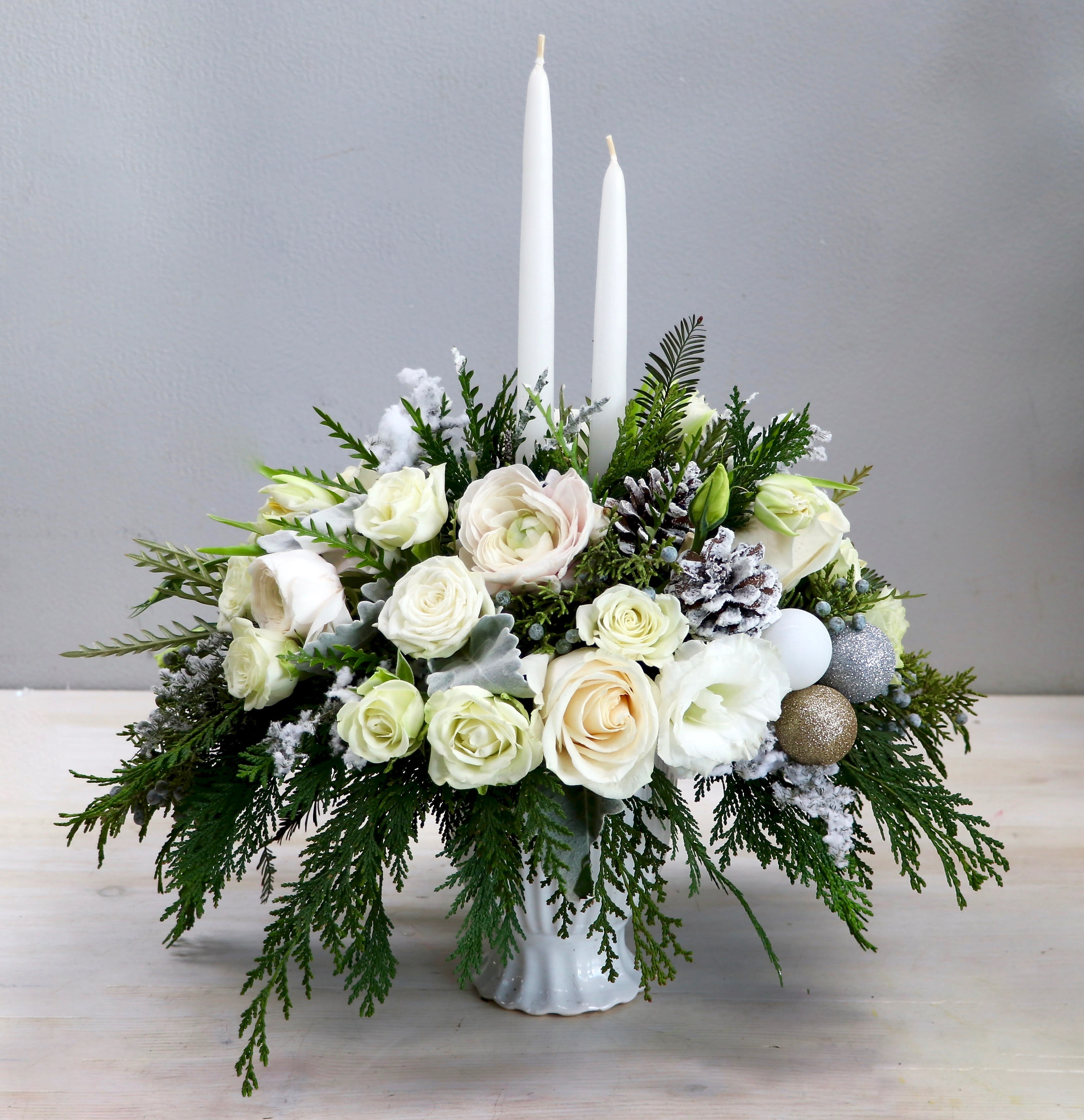New Year Wintertide - My Glendale Florist  - Start the year right with beautiful blooms in your home! This centerpiece has a mix of roses, ranunculus, and seasonal greenery perfect for the holidays. Be sure to upgrade for more blooms! 