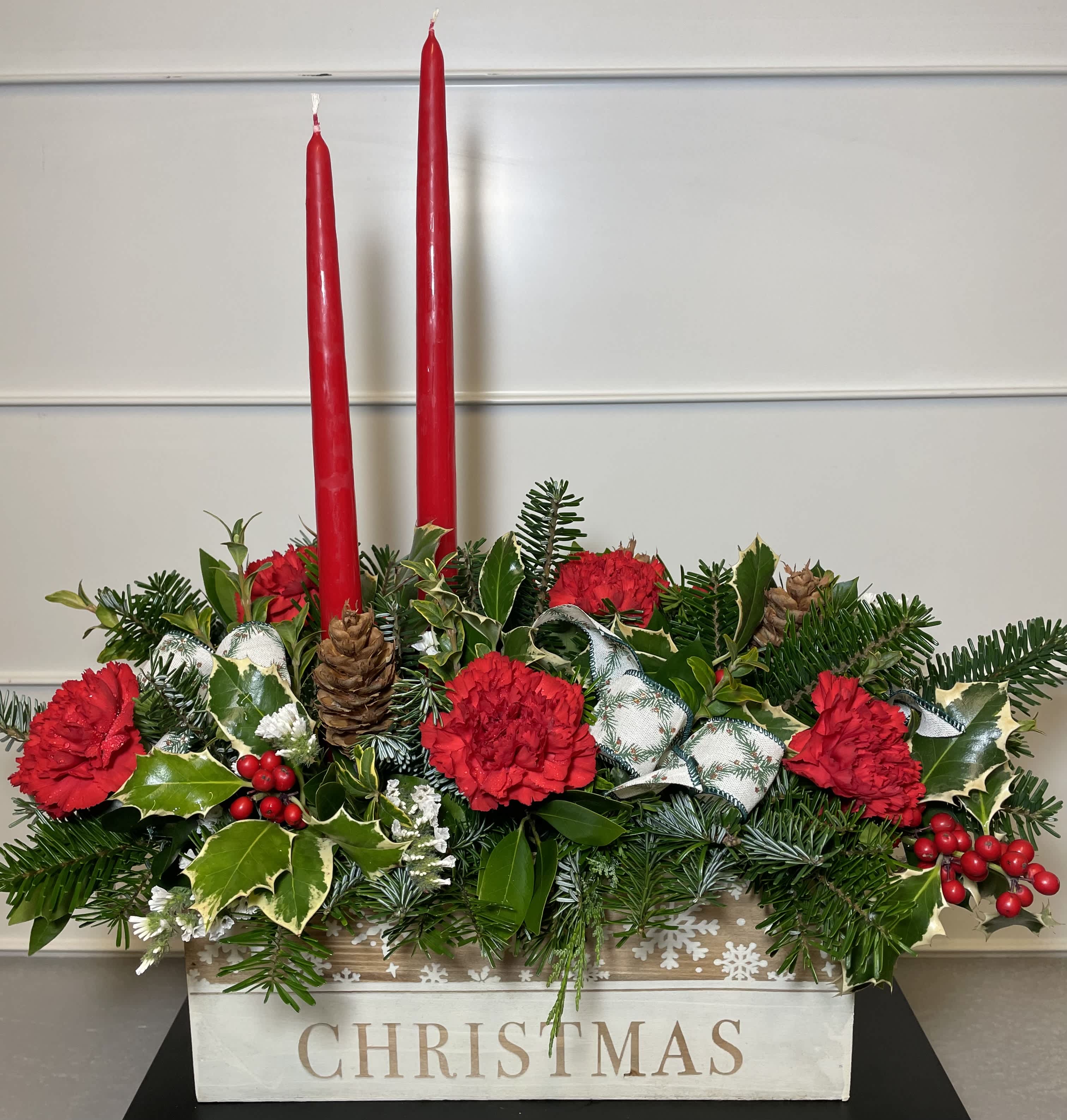 Box of Cheer - This holiday box arrangement features carnations, holly, pinecones, and Christmas greens with taper candles. *Box choices may vary.