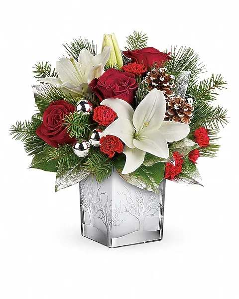 Frosted Forest - With its festive charm and classic Christmas style, this hand-arranged bouquet delivered in a gorgeous glass cube with silver tree details is a delightful holiday surprise. Red roses, white asiatic lilies and red miniature carnations are accented with douglas fir, white pine, and lemon leaf. Delivered in a Woodland Winter cube.