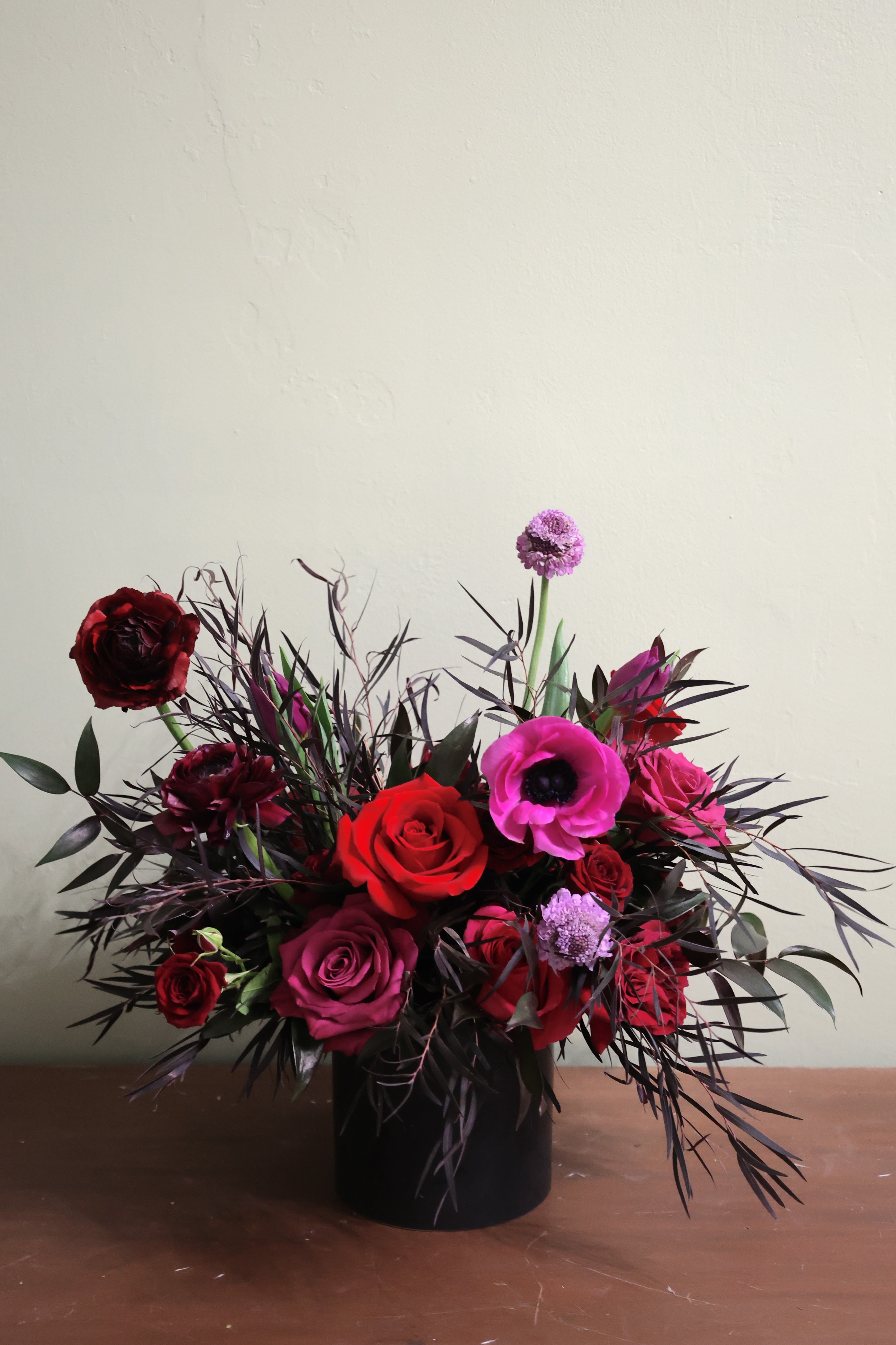 Dark Magic - A dark yet bright mix of red, burgundy and fuchsia in dark foliage, made in a ceramic container