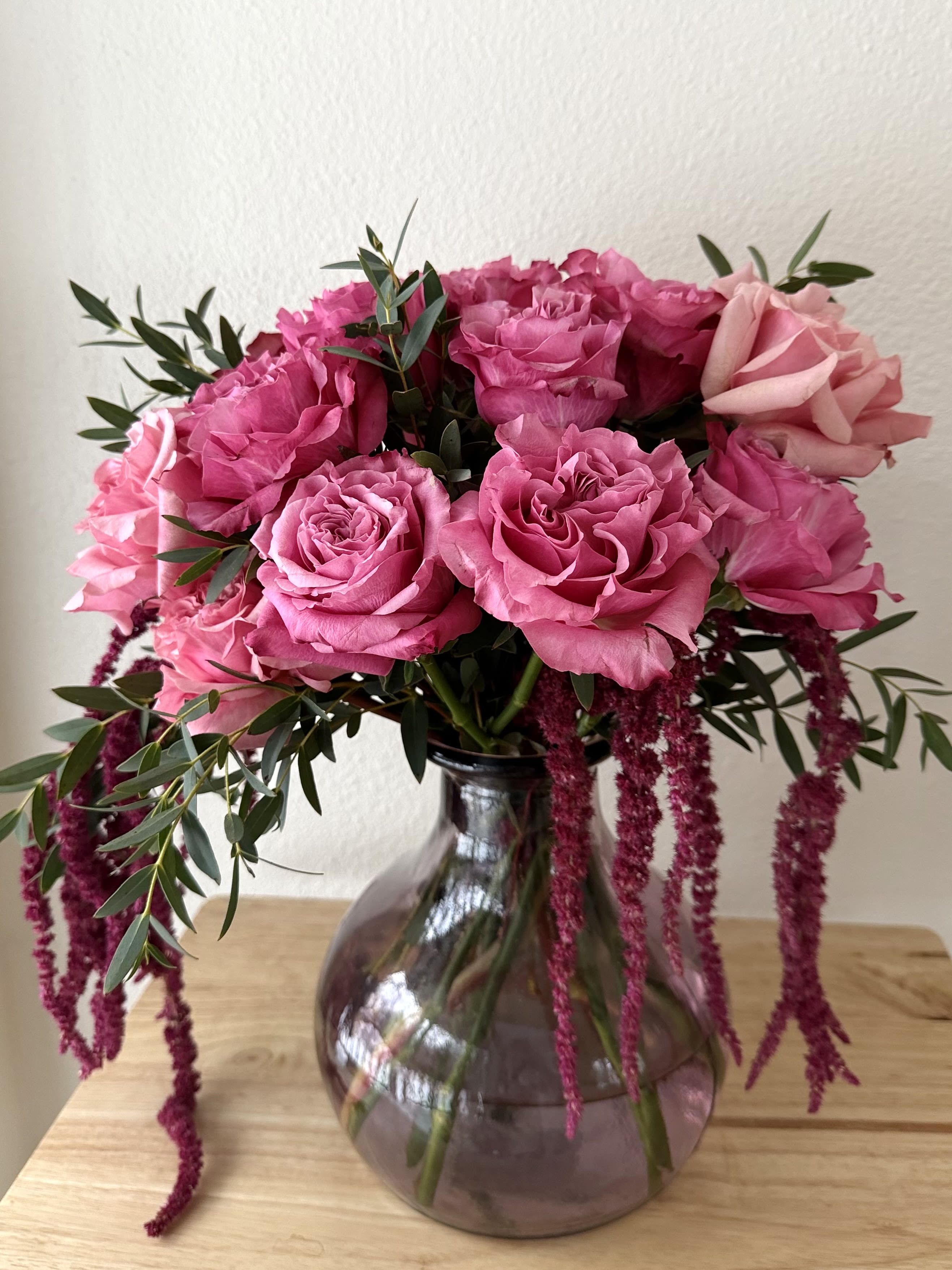 Raspberry Velvet - A lush, vibrant arrangement of rich pink roses paired with cascading amaranthus and fresh greenery. Bold, romantic, and full of movement — a statement piece that brings warmth and elegance to any space.