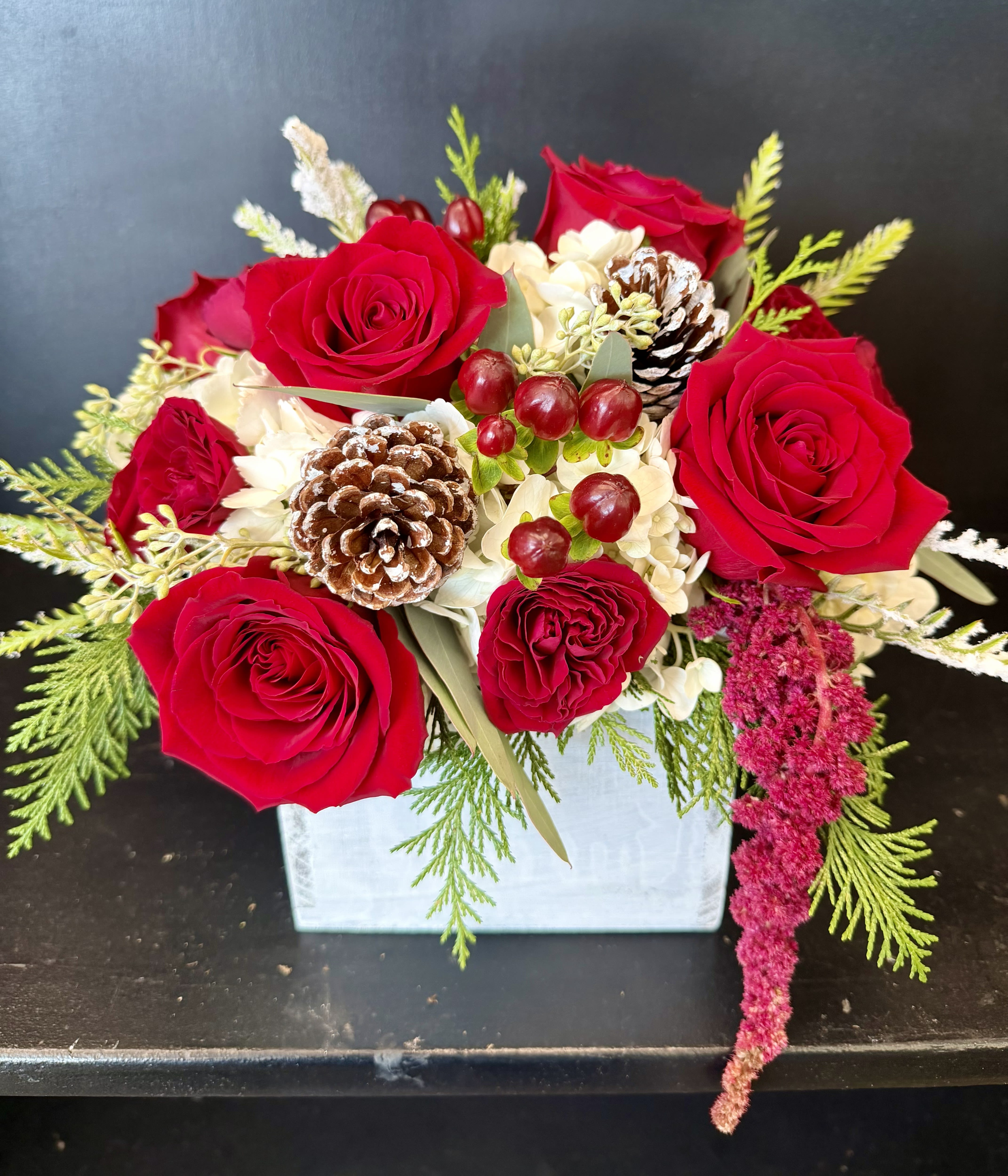 Wynter's Wonderland - a Red and White with pine cones Christmas mixed arrangement in a white wooden box 